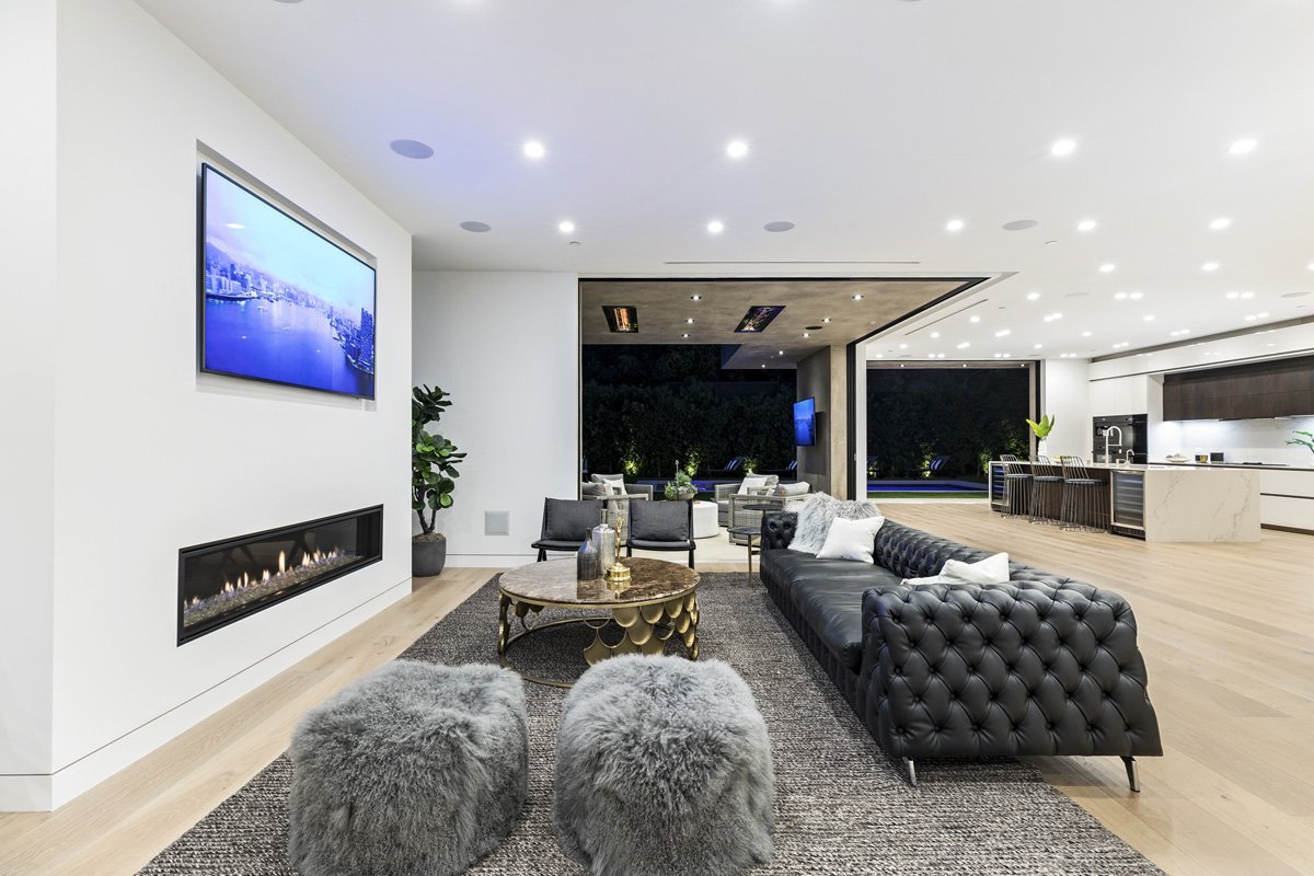 Beverly Hills open-concept living room with linear fireplace and full-height sliding glass walls