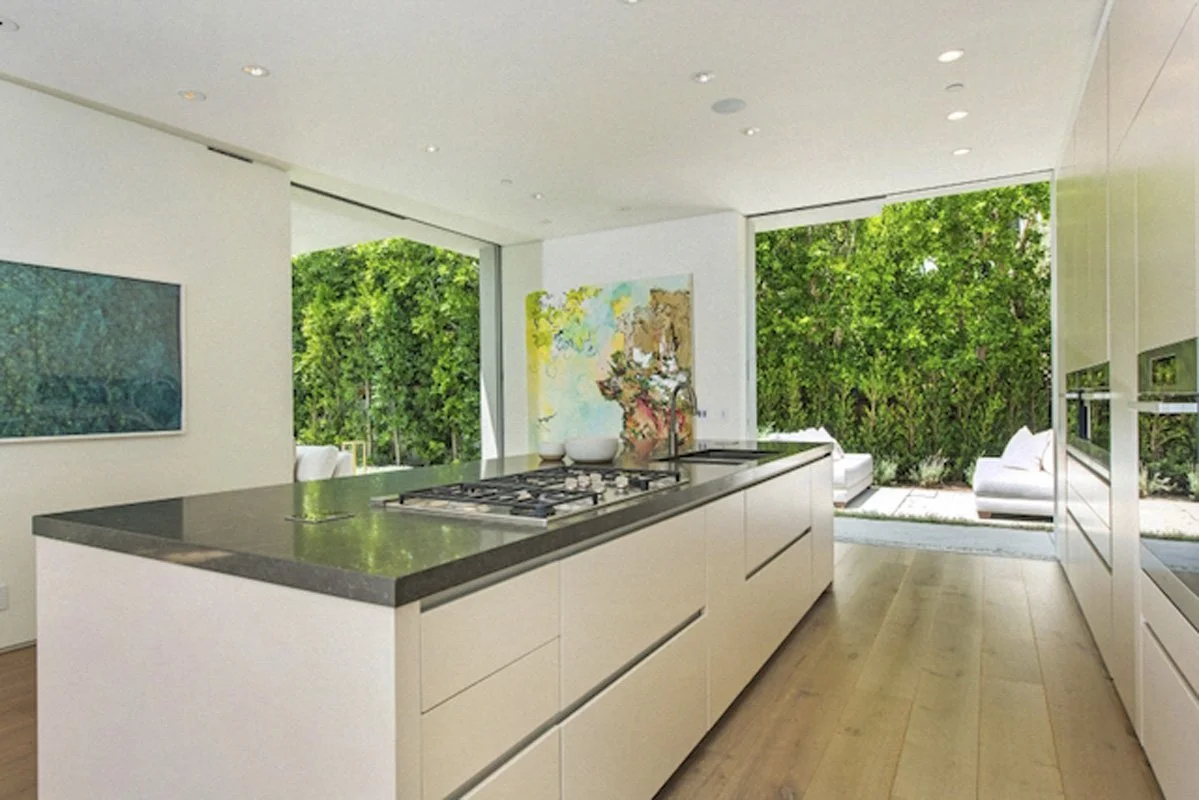 Minimalist kitchen in West Hollywood modern home with long island and integrated cabinetry.