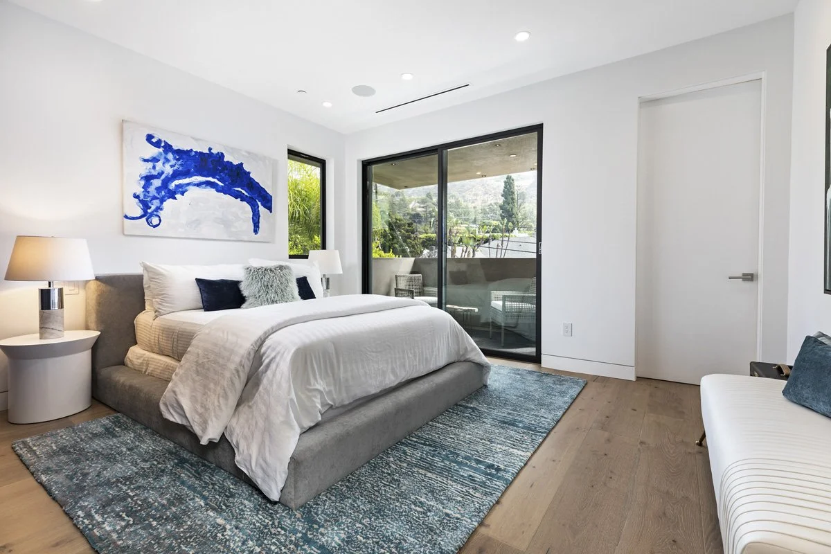 Beverly Hills covered balcony lounge with minimalist outdoor furniture and landscaped backdrop