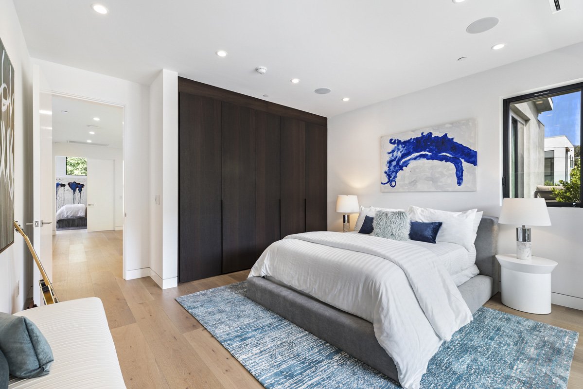 Beverly Hills guest bedroom with custom walnut closet doors and wide-plank oak flooring