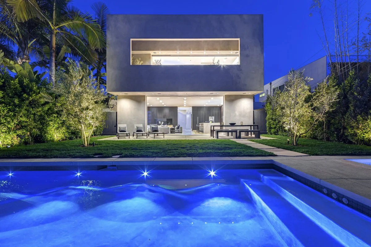 Contemporary West Hollywood custom home at dusk with illuminated facade and backyard pool