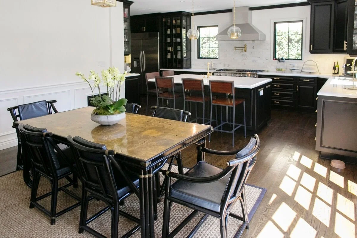 Dining area connected to kitchen with marble island and brass lighting in Hancock Park remodel