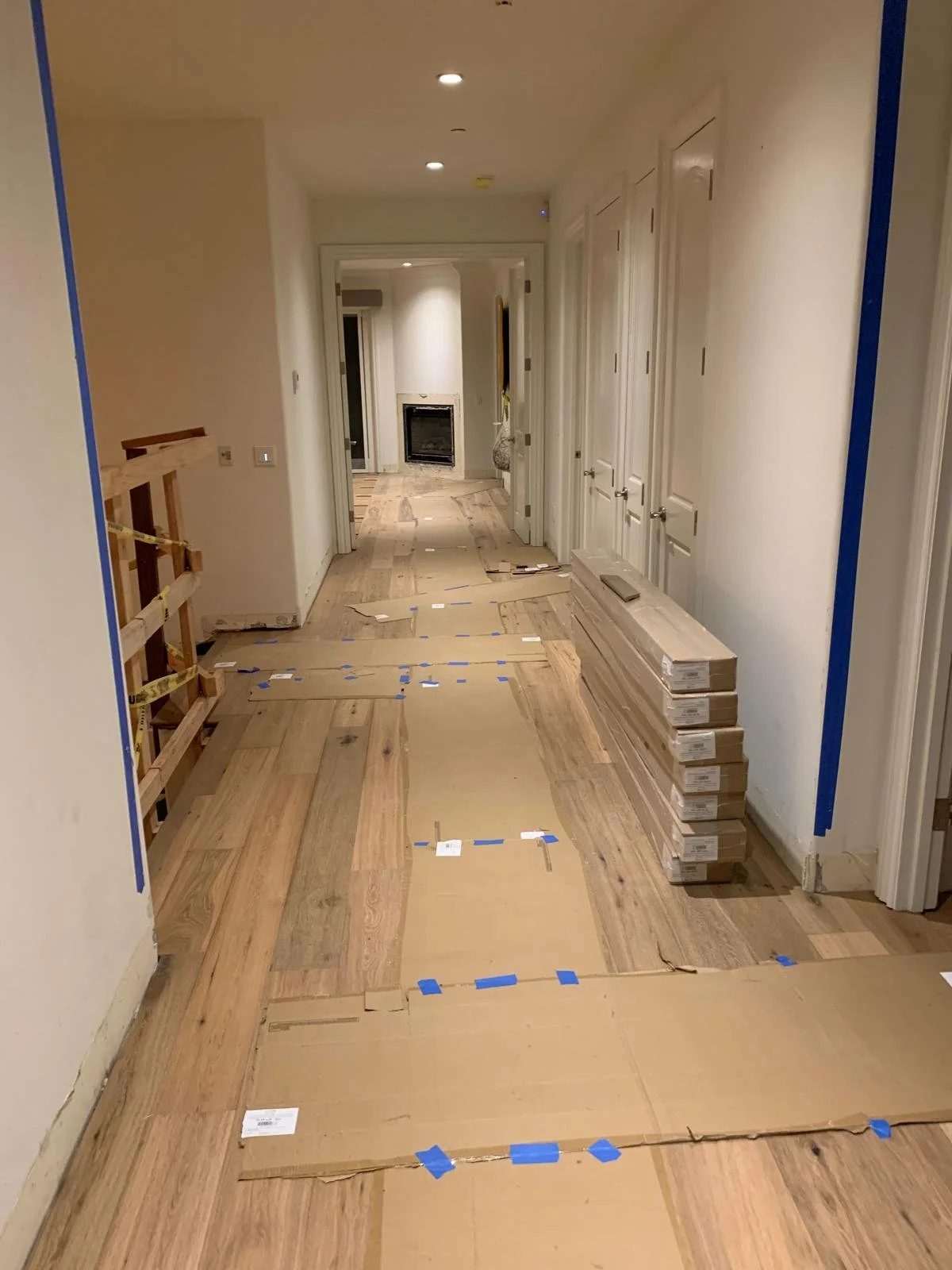 Hallway construction phase in Brentwood custom home with installed wood flooring and ongoing interior finish work