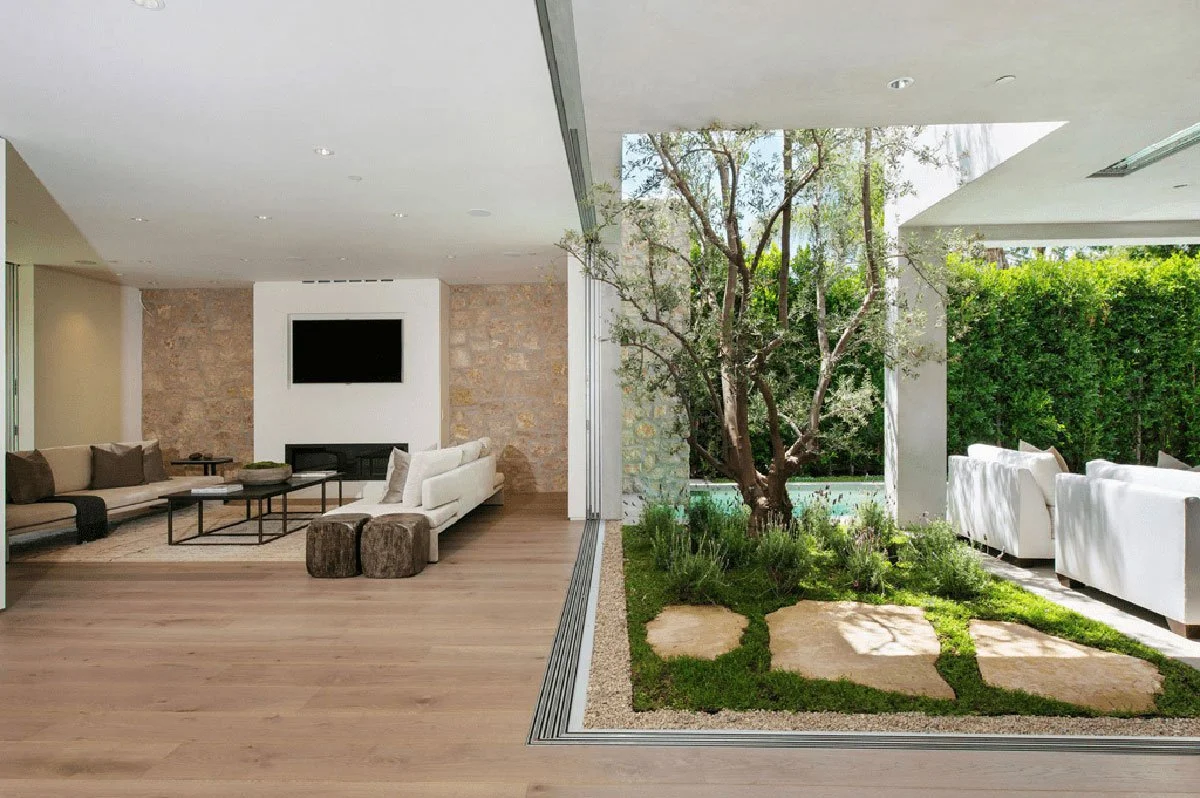 Modern indoor outdoor courtyard living space with sliding glass walls in West Hollywood custom home