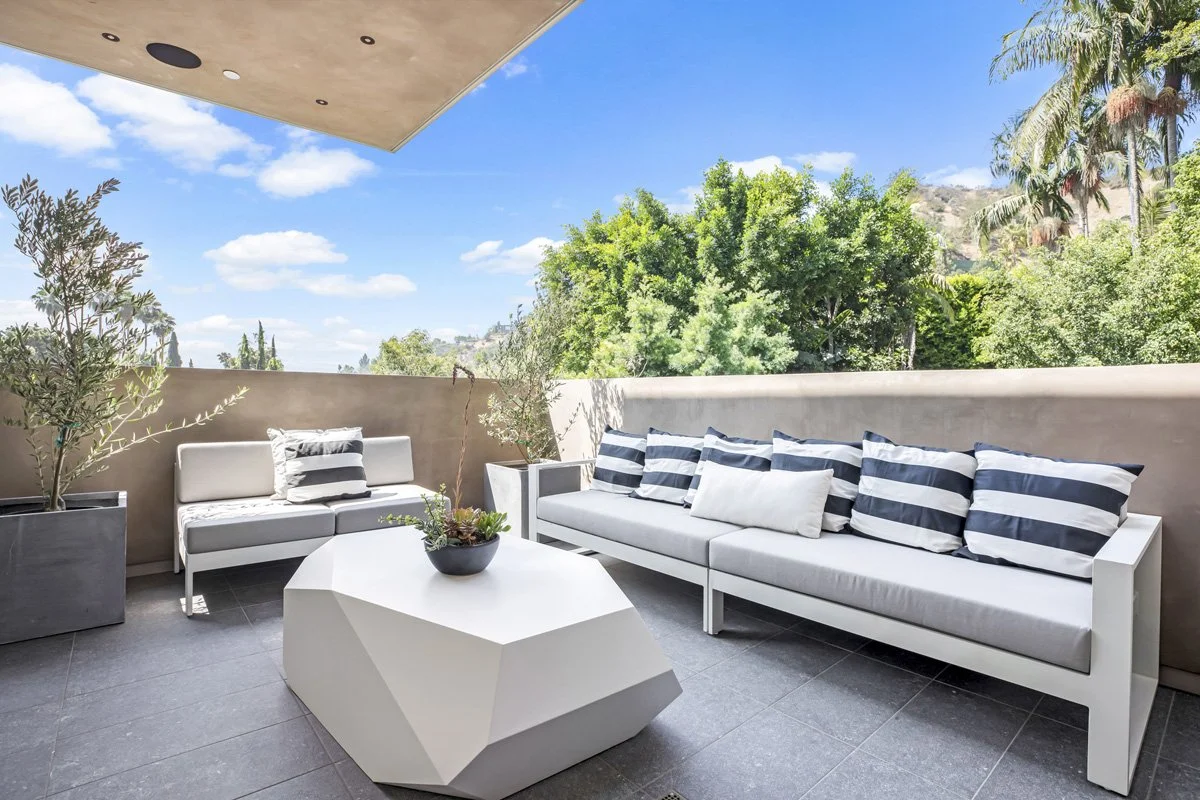 Beverly Hills private terrace with modern outdoor seating, geometric coffee table, and hillside views