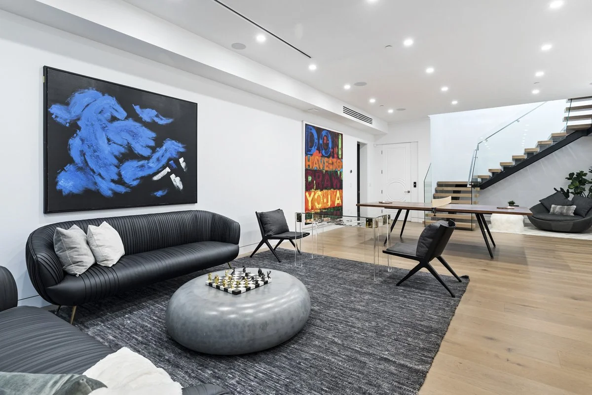 Beverly Hills open lounge area with floating staircase, wide-plank oak floors, and contemporary art collection