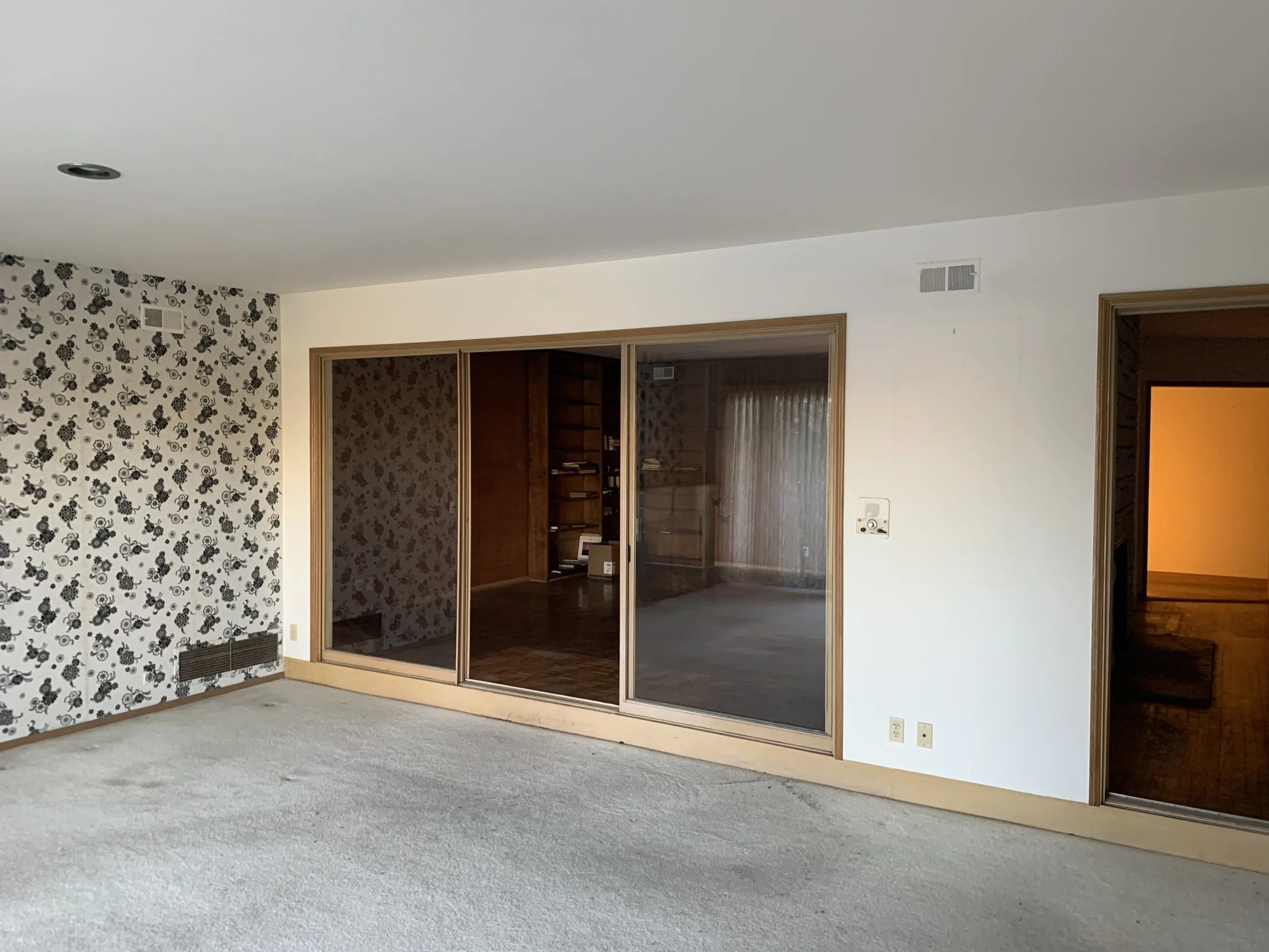 Culver City home before remodel with closed-off living area, carpet flooring, and sliding glass doors separating interior spaces