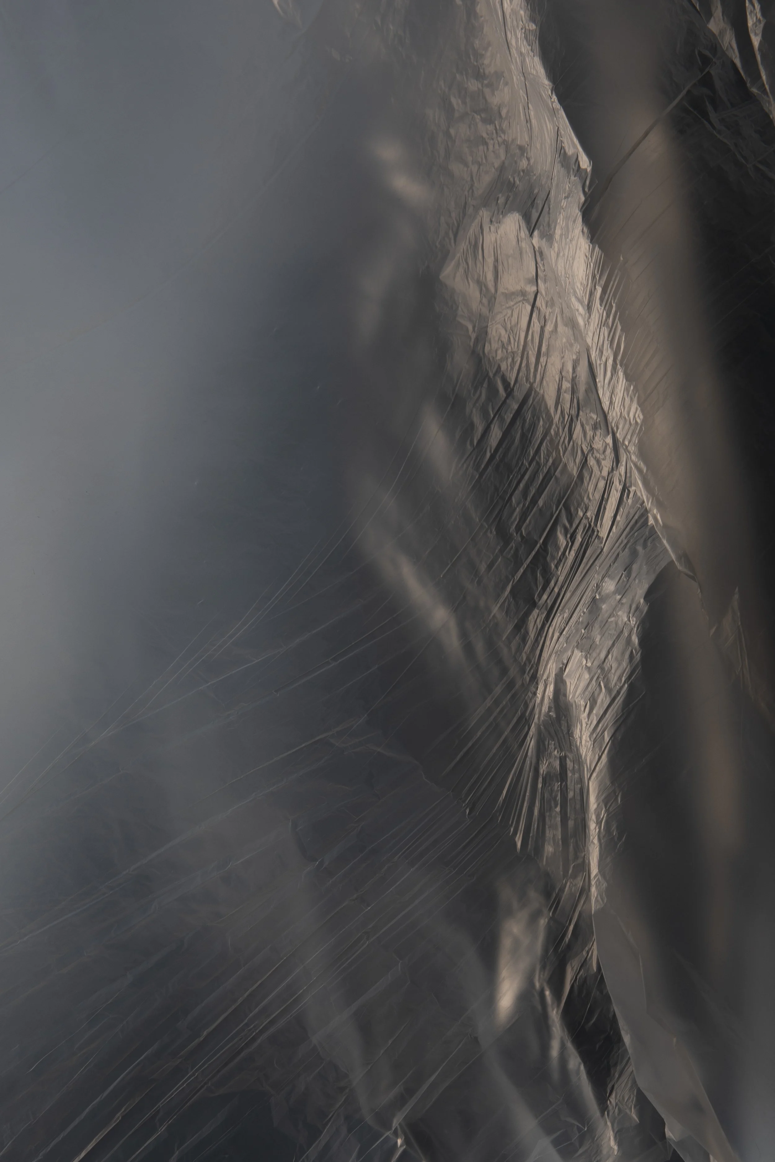 Monochrome photographic study of layered foil folds, evoking the organic softness of clouds and transient atmospheric states.