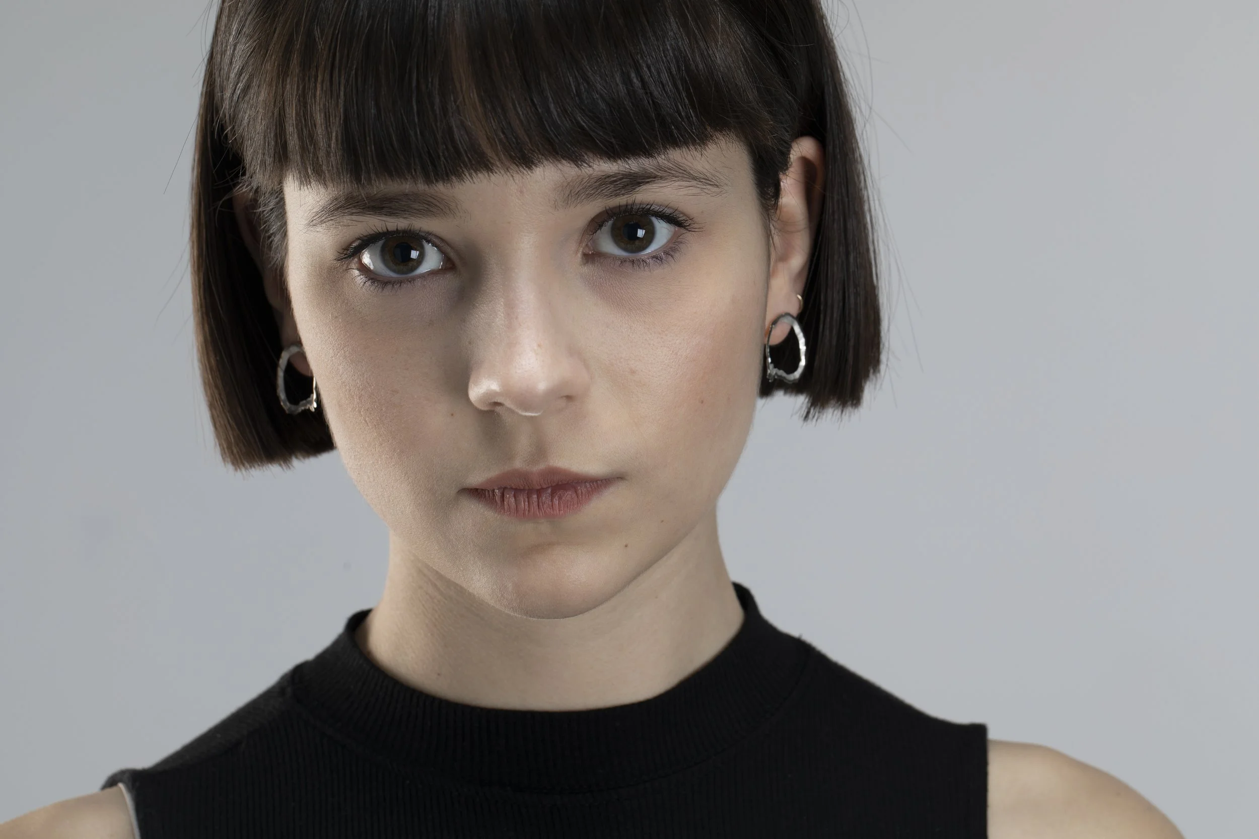 Model presenting handcrafted circular silver earrings from the Fleeting Fragments collection, showcasing a raw, organic surface texture.
