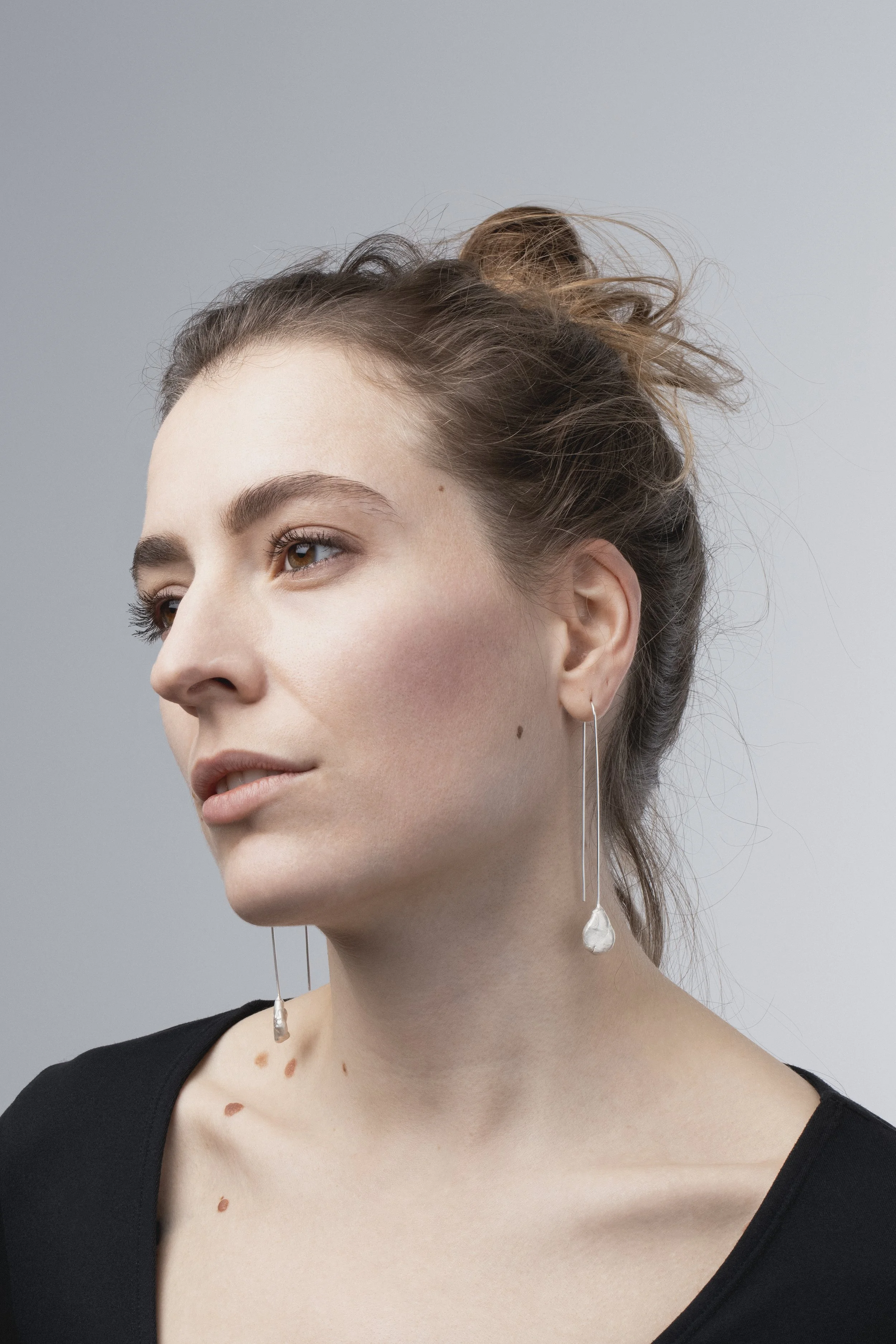 Stunning portrait of model Laura Prahl showcasing the long, sculptural Momentum silver earrings, emphasizing their light and elegant presence.