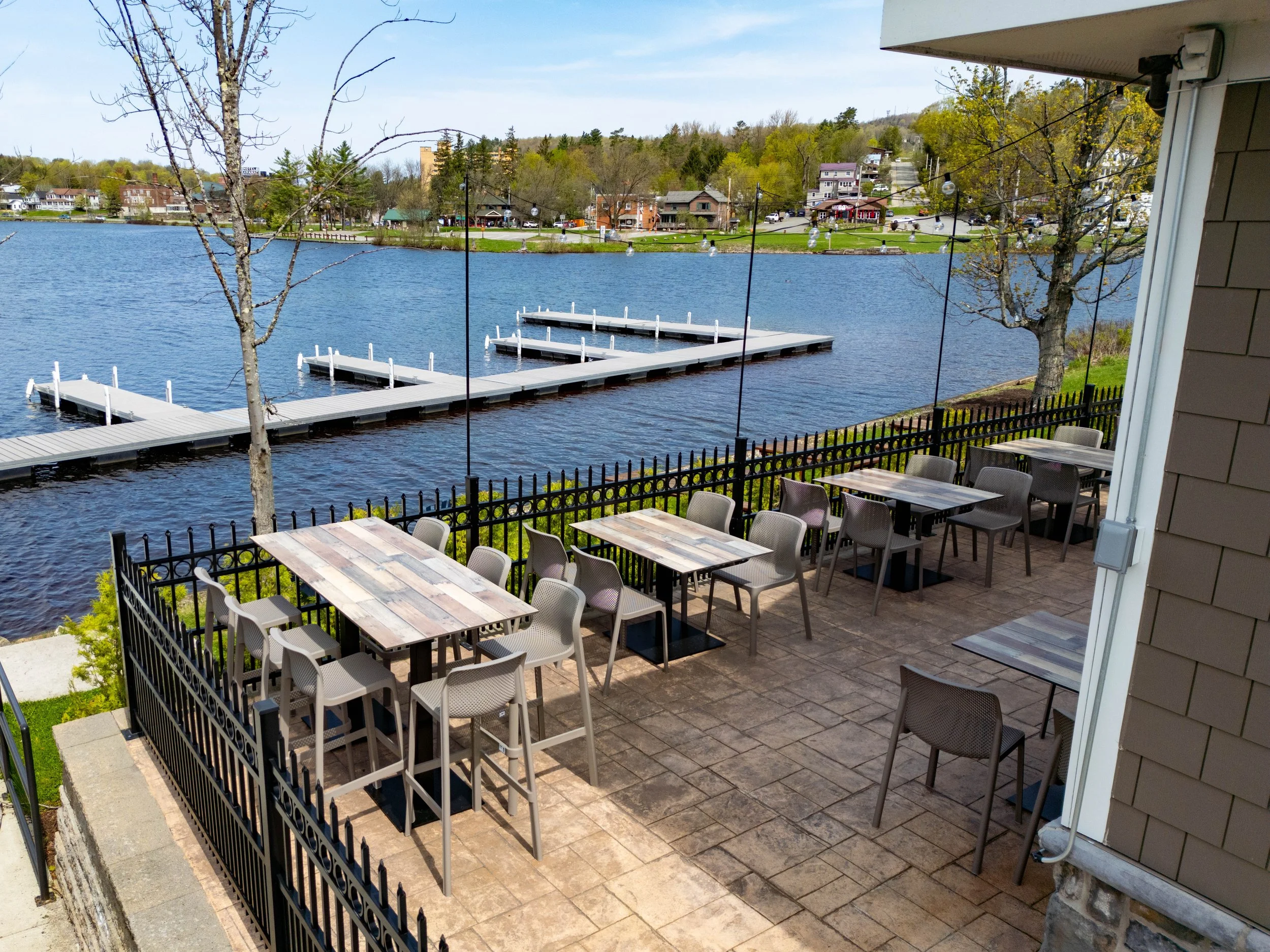 Outdoor patio with tables and chairs overlooking Lake Flower with public boat slips.