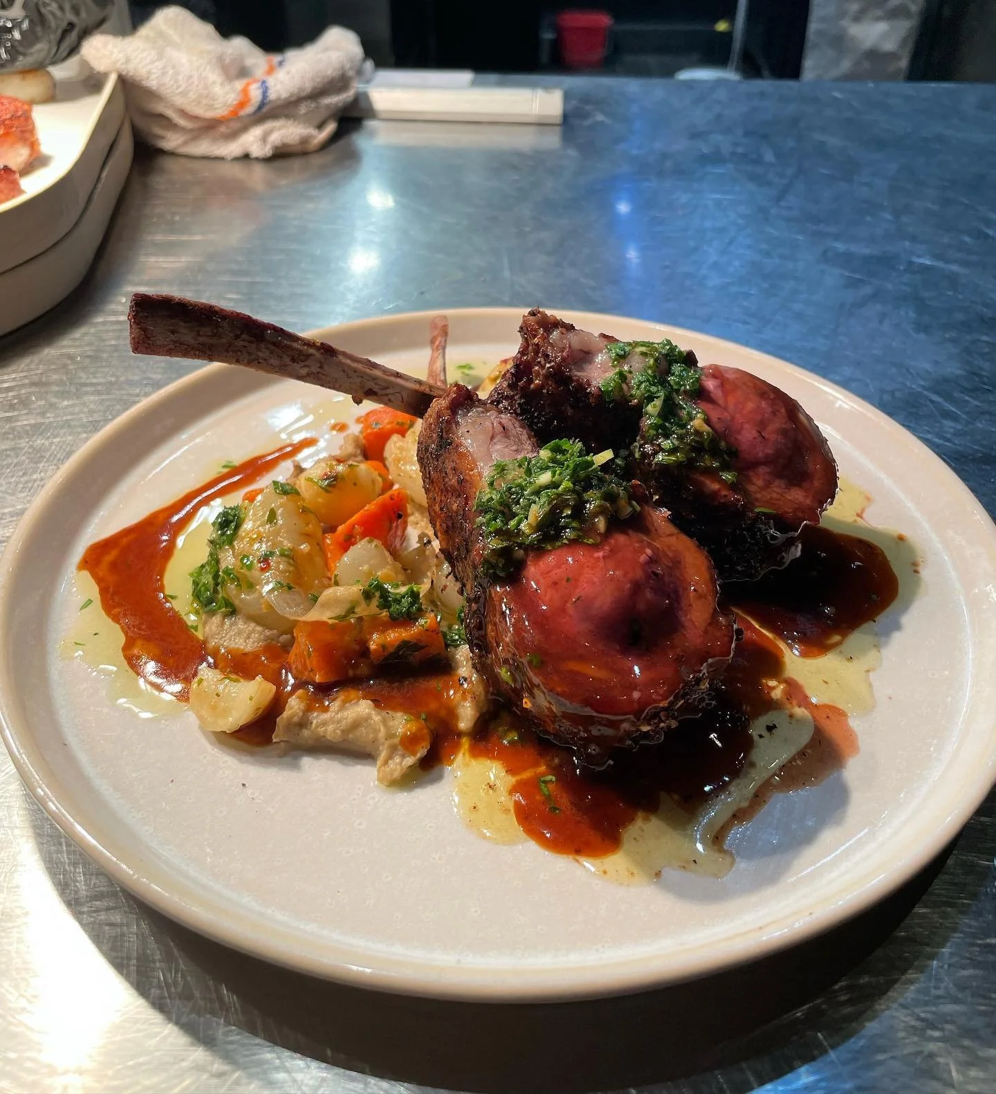Za&rsquo;atar lamb rack over baba ghanoush and pan roasted root vegetables finished with a chimichurri and lamb demi
