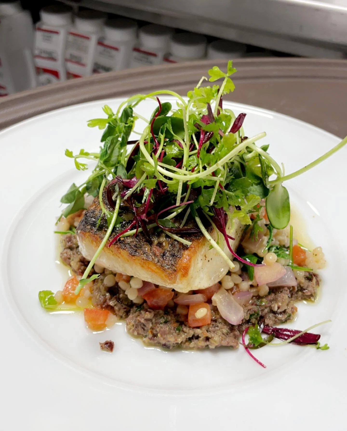 Crispy skin grouper over Mediterranean couscous, olive tapenade, and a citrus micro-intensity herb salad