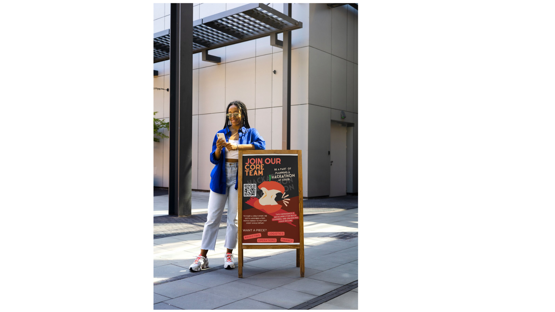 A girl is standing next to a billboard. The billboard is inviting students to lead a core Hackathon team.