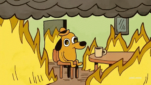 Cartoon dog sitting calmly in a room filled with flames and smoke.