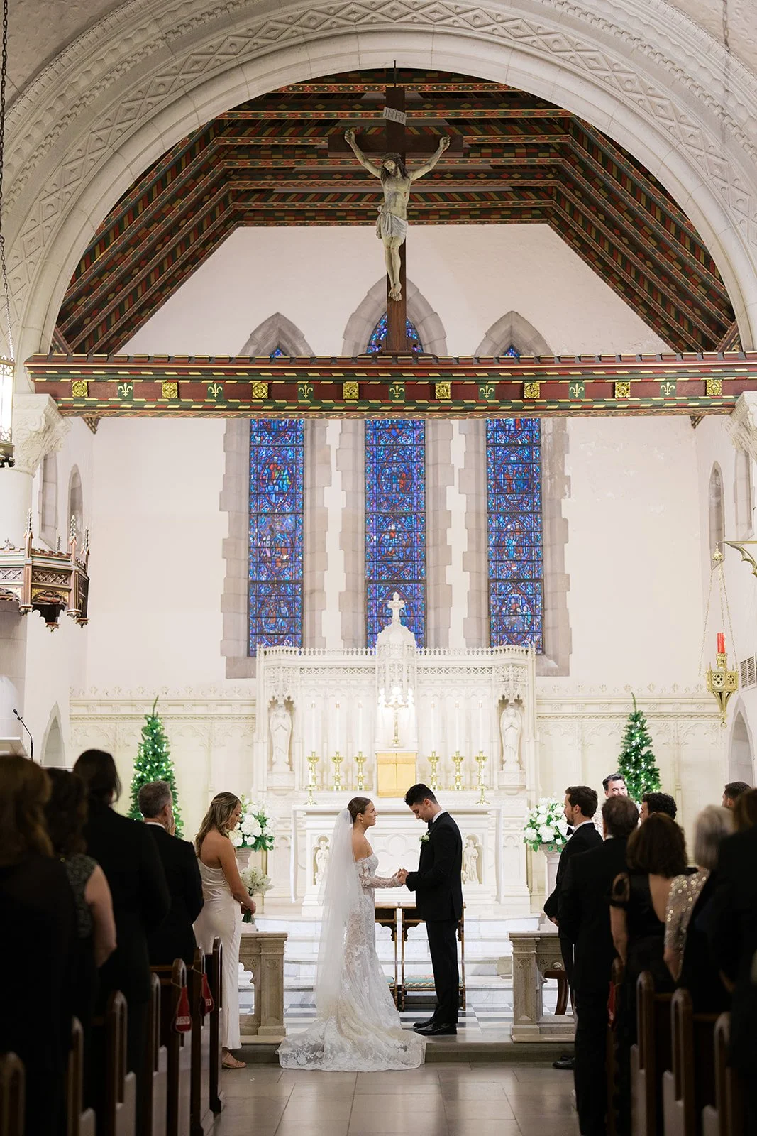 A sacred, sweeping moment. Their “I do” framed by soaring architecture and glowing light.