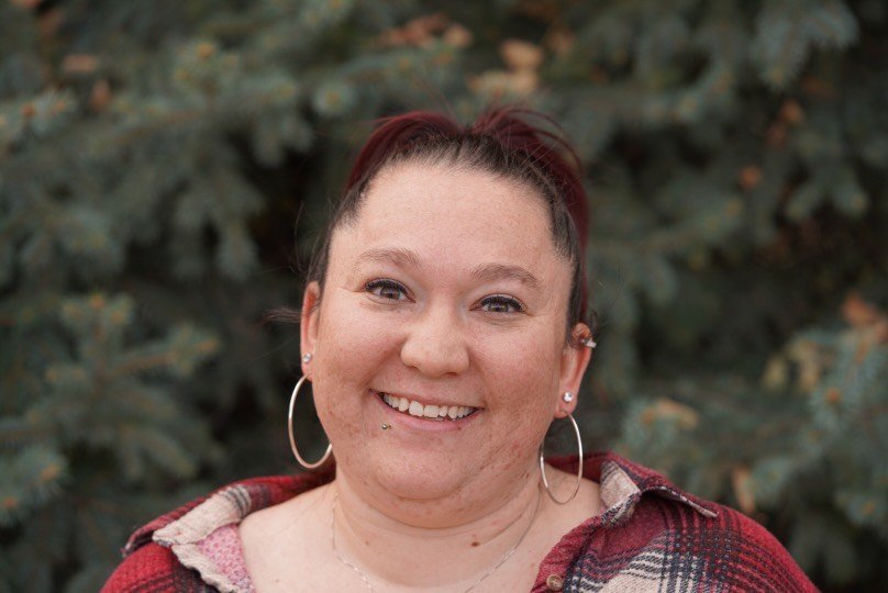 Stylized illustration of a woman with a bun hairstyle and no facial features.