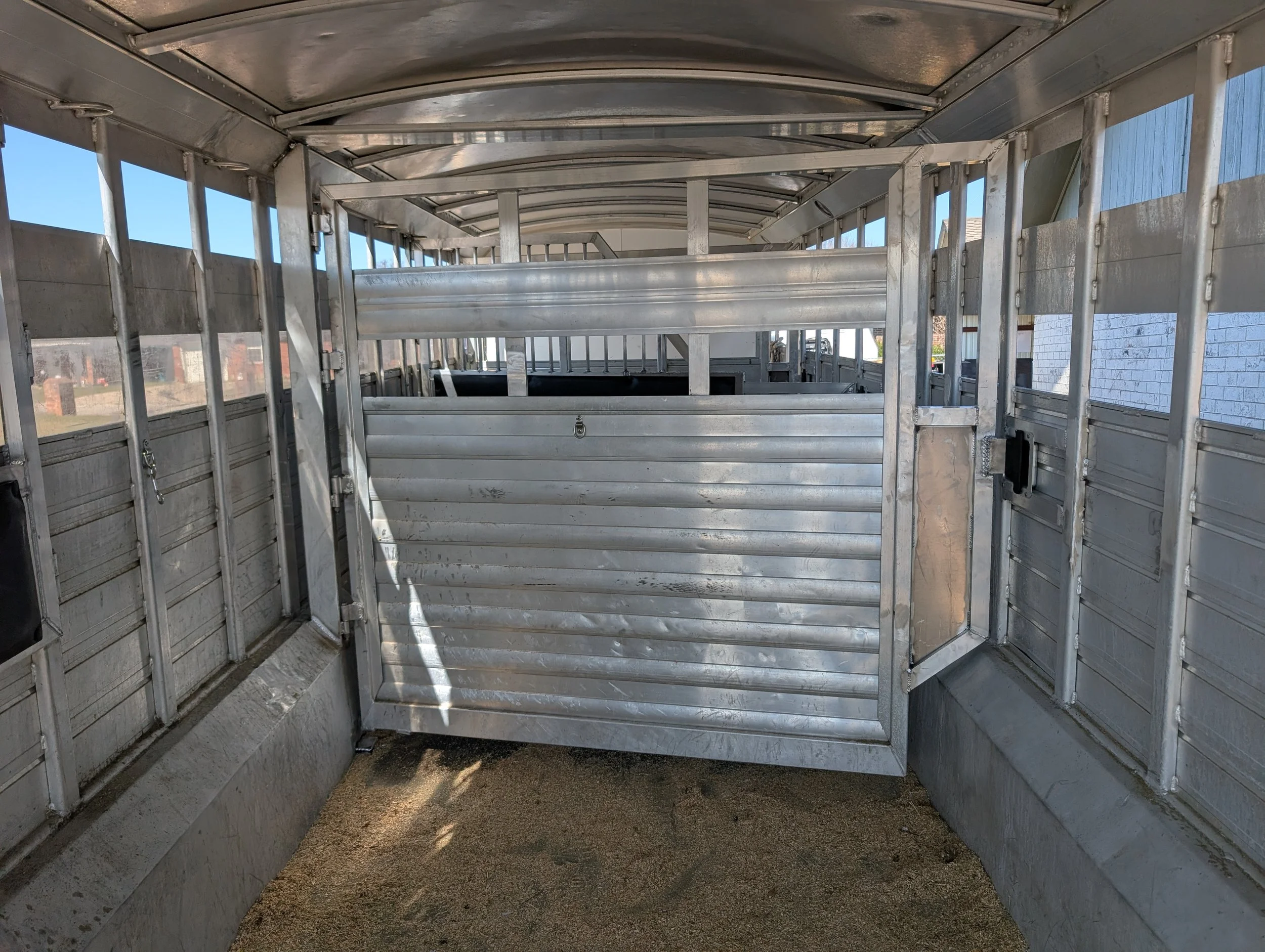 Custom flip-up horse trailer divider fabricated for a steel livestock trailer conversion.
