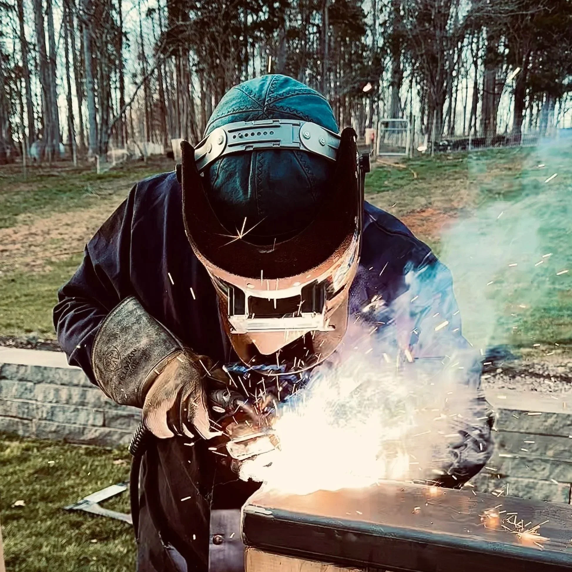 Welder performing on-site mobile welding and custom metal fabrication.