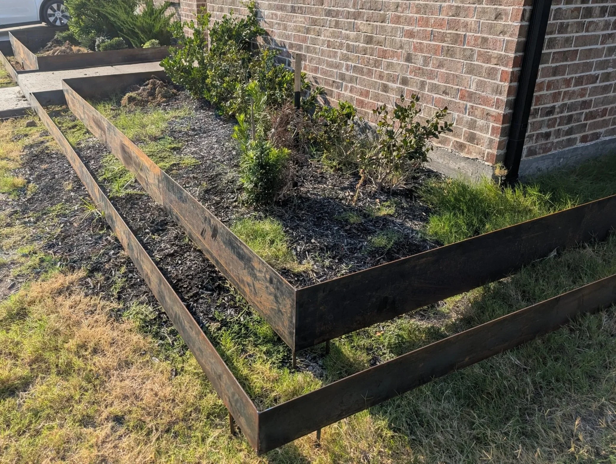 Custom welded steel garden planters installed at a residential property in Prosper, TX by JH Tig Works LLC.