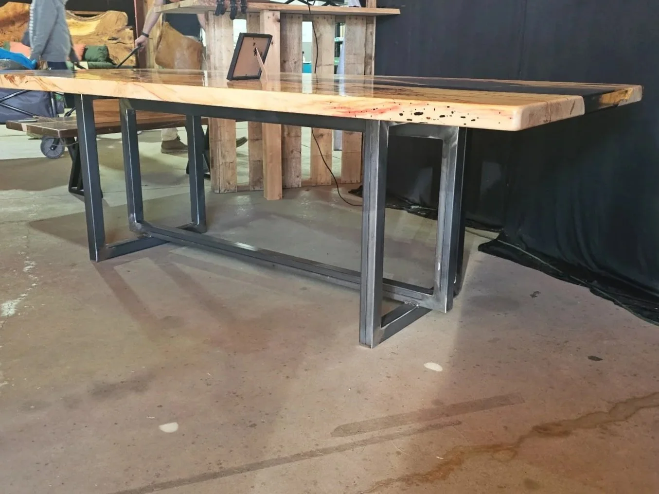Finished wood table with custom fabricated steel base welded by JH Tig Works LLC in North Texas