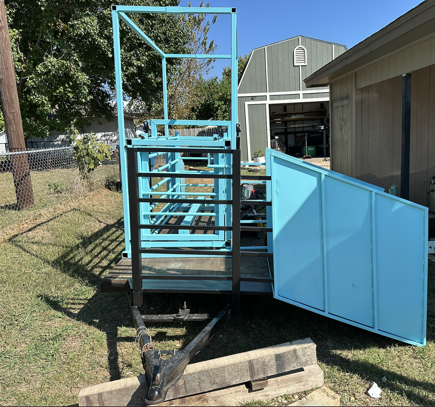 Hydraulic pig chute front gate assembly with custom access doors and steel fabrication.