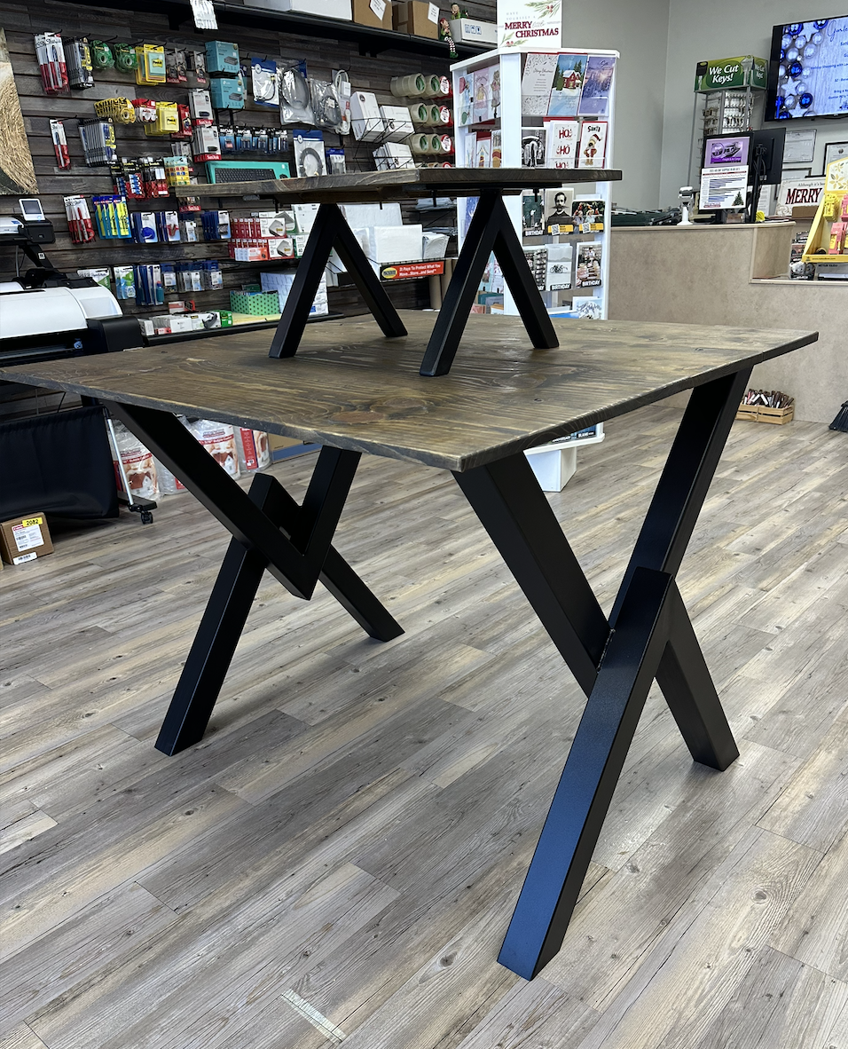 Custom steel table with powder-coated angled legs and a solid wood top, built for strength and a modern industrial look in a retail setting.