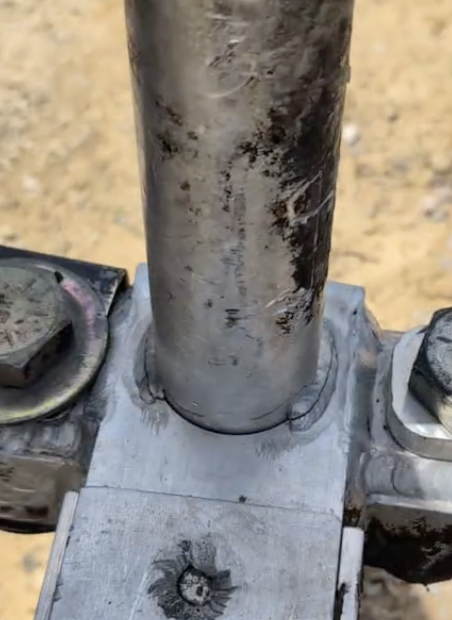 Cracked steel frame on asphalt paving equipment before structural welding repair by JH Tig Works LLC.