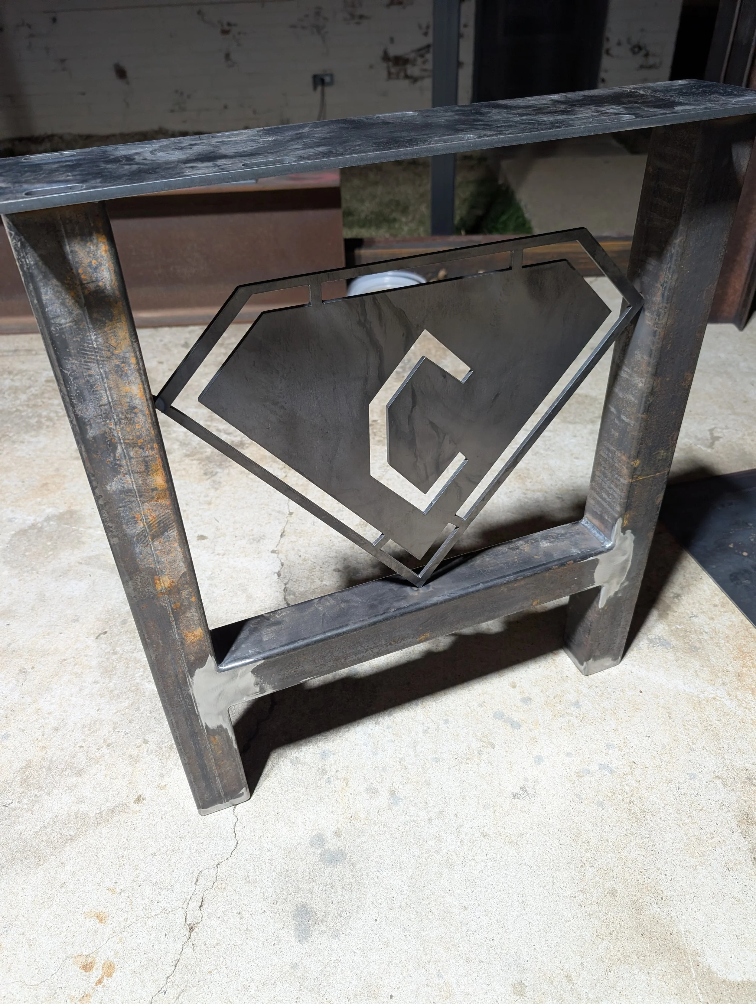 Custom steel conference table base with fabricated company logo detail