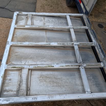 Underside of damaged aluminum horse trailer ramp showing frame damage before repair.