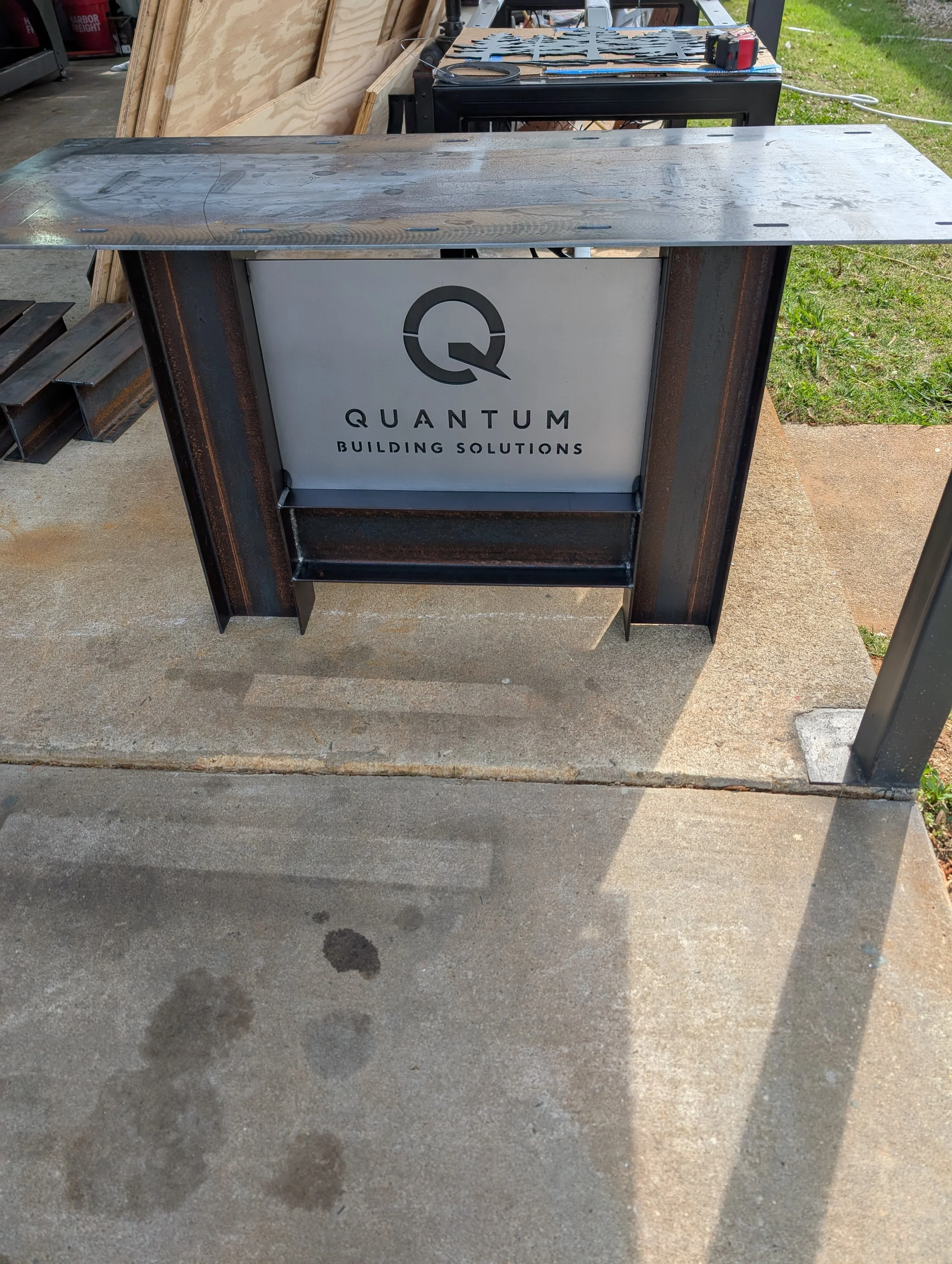 Commercial steel conference table base with custom Quantum Building Solutions branding