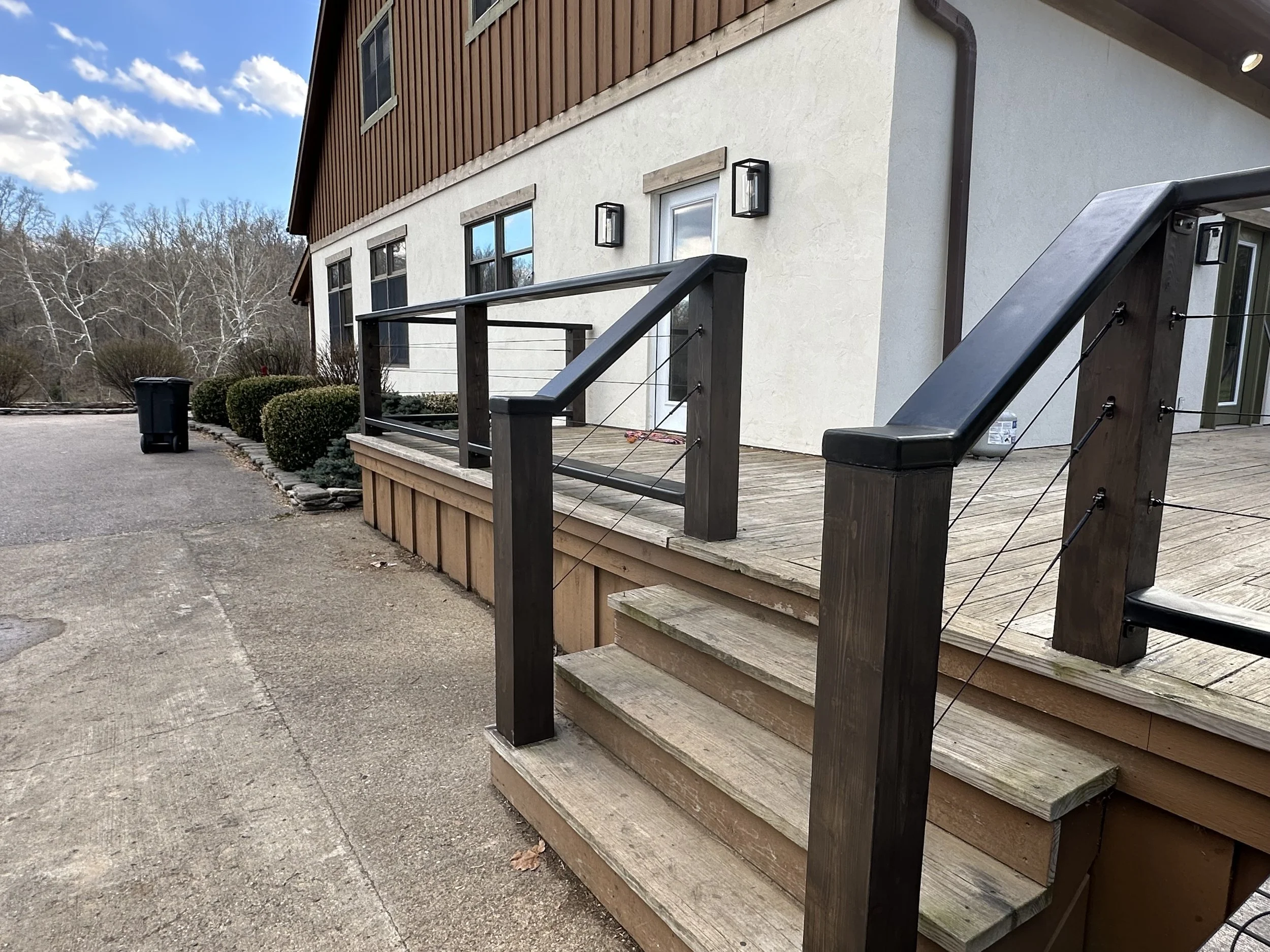 Finished custom cable patio railing with welded steel frame and horizontal cable infill.