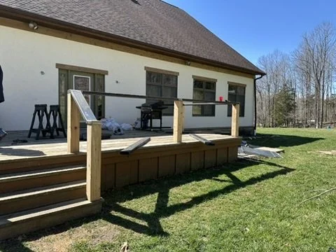 Custom black steel cable railing installed along an outdoor patio and deck.