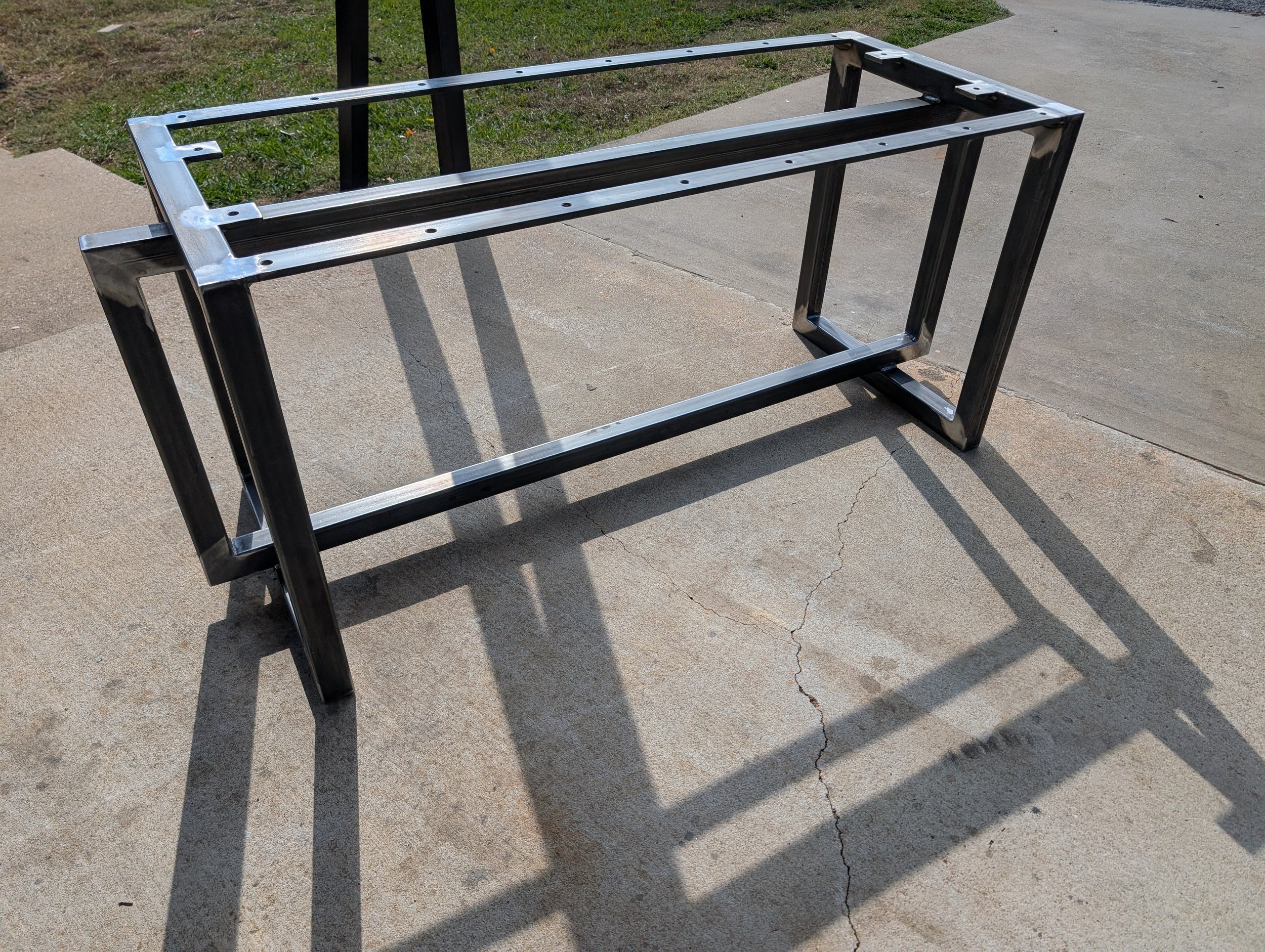 Custom steel table base fabricated from heavy-duty square tubing with precision-drilled mounting plates. Built for strength, stability, and clean industrial design to support solid wood table tops.