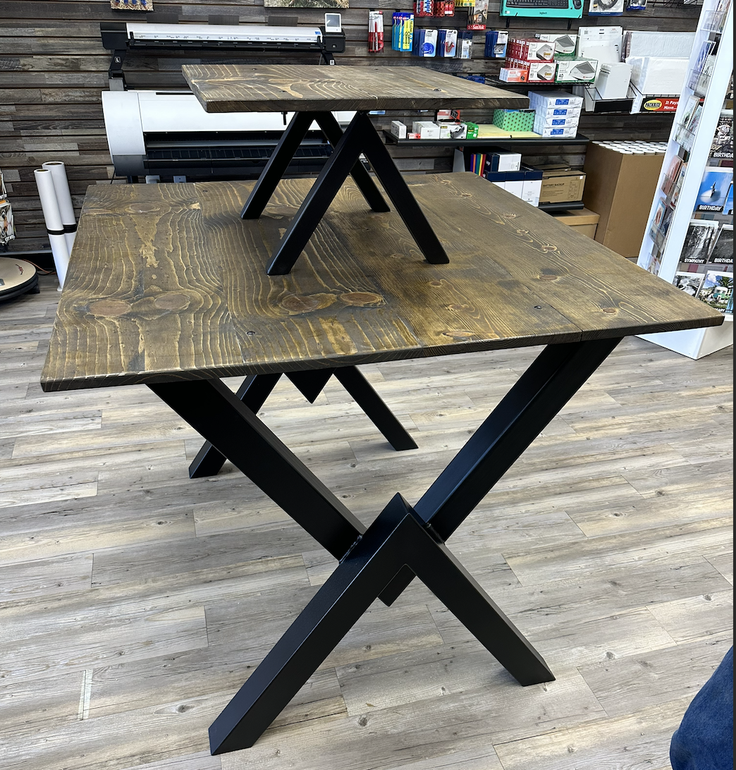 Close-up view of custom powder-coated steel table legs paired with a stained wood top, highlighting clean lines and sturdy construction.