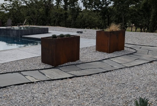 Long rectangular steel planter fabricated for a modern residential landscape design.