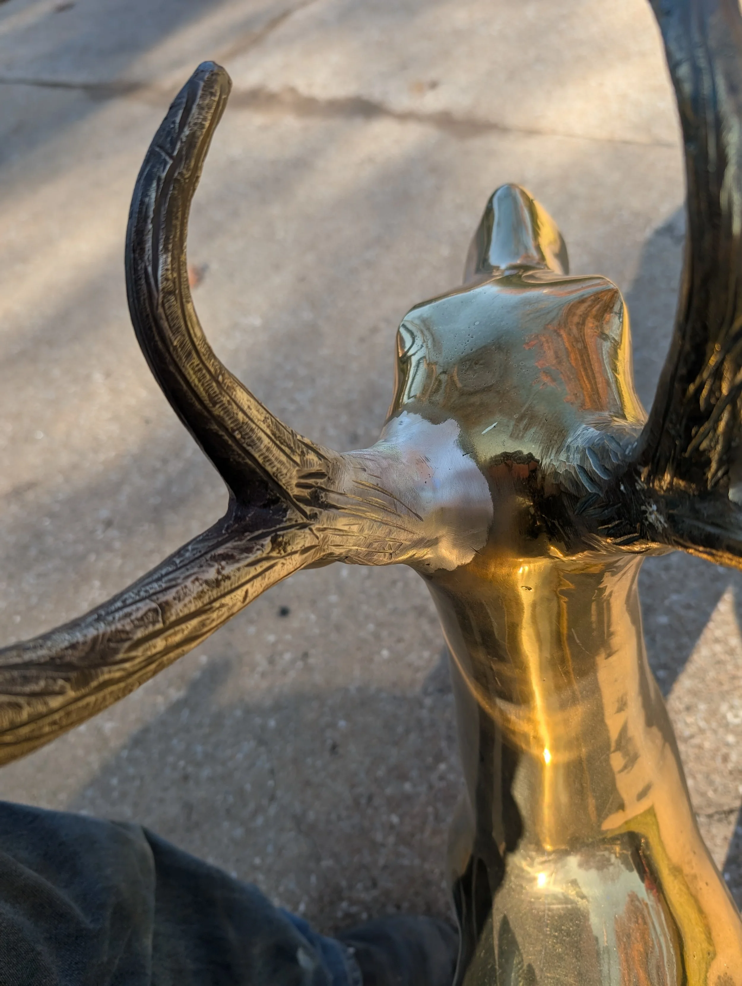 Close-up view of the brass deer’s head and antlers, showcasing detailed shaping, smooth transitions, and hand-finished brass fabrication.
