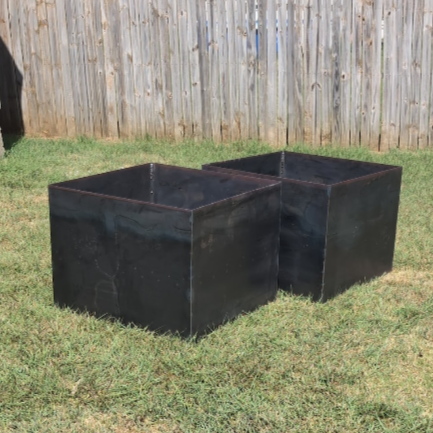 Close-up of custom welded steel garden planter installed with landscaping in Prosper, TX