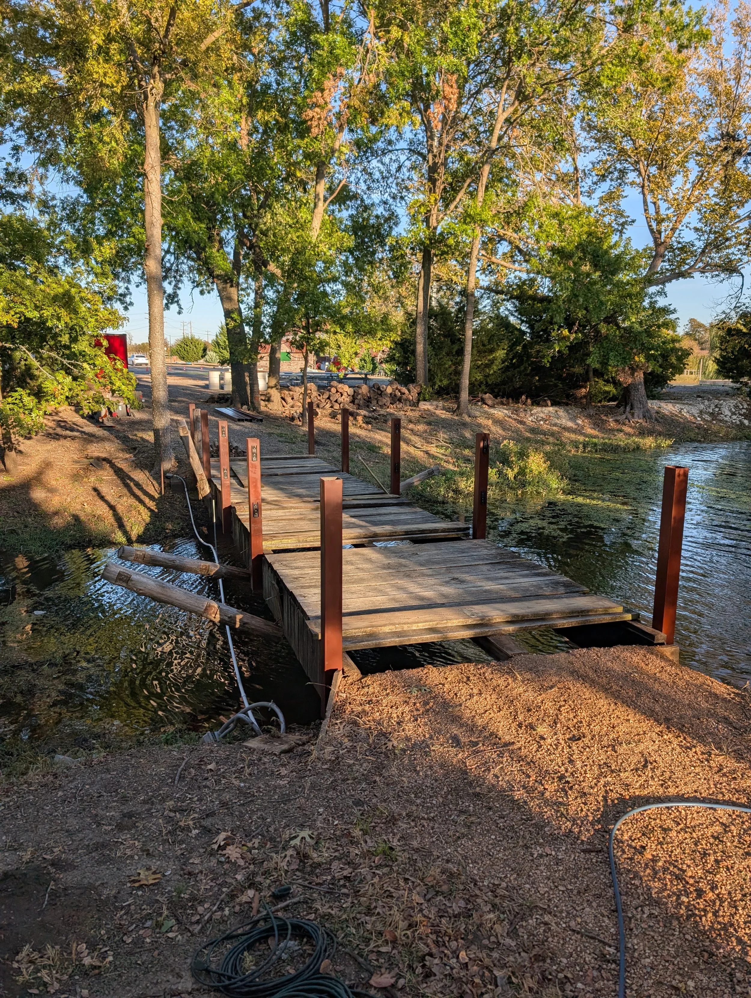 Heavy-duty steel railing posts mounted to an existing wooden footbridge, designed to improve safety while maintaining a clean, modern appearance for outdoor walkways.