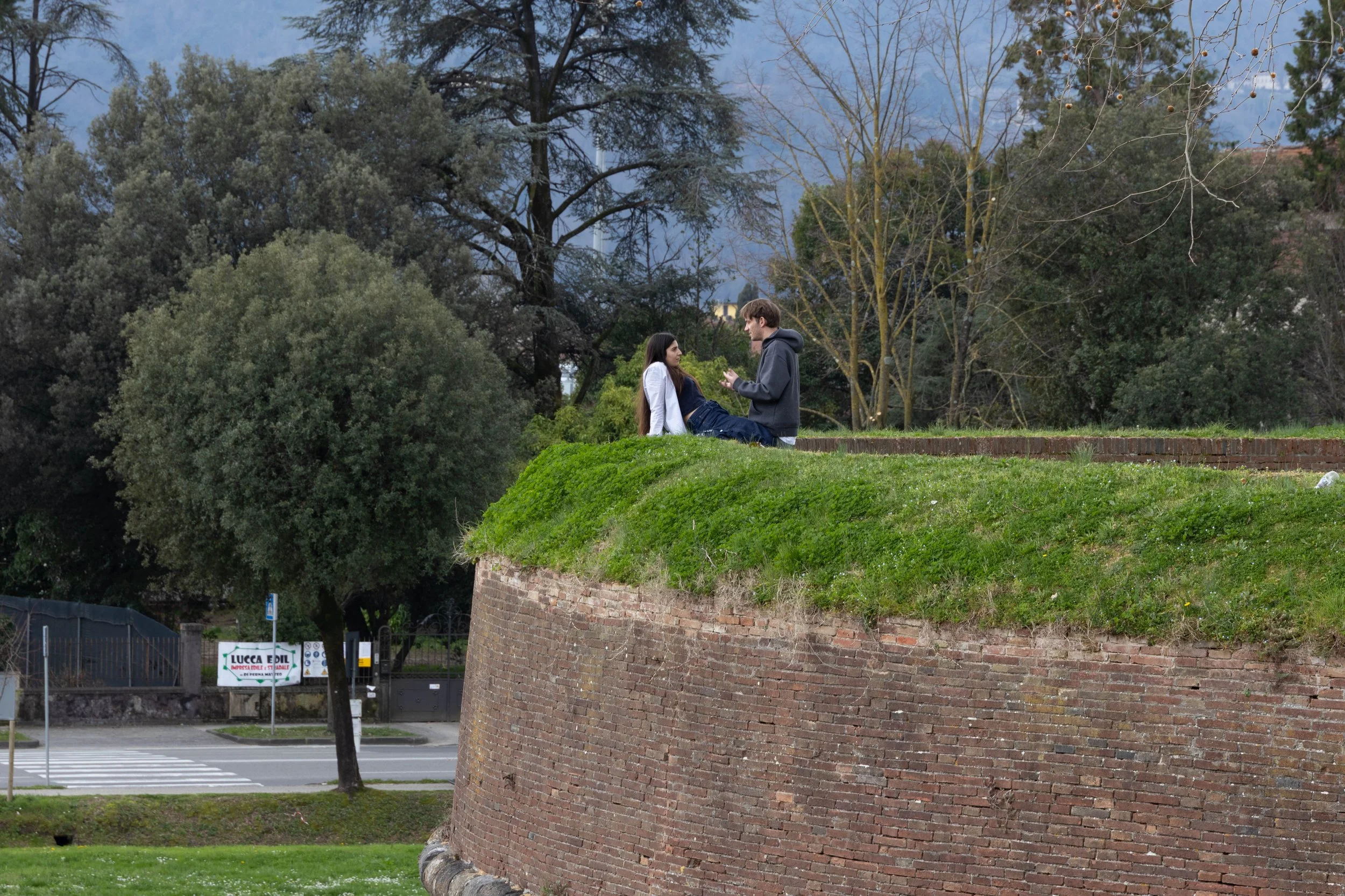 Lucca, Italy | A quiet moment shared atop Lucca's Renaissance walls, where centuries of history meet everyday life. 