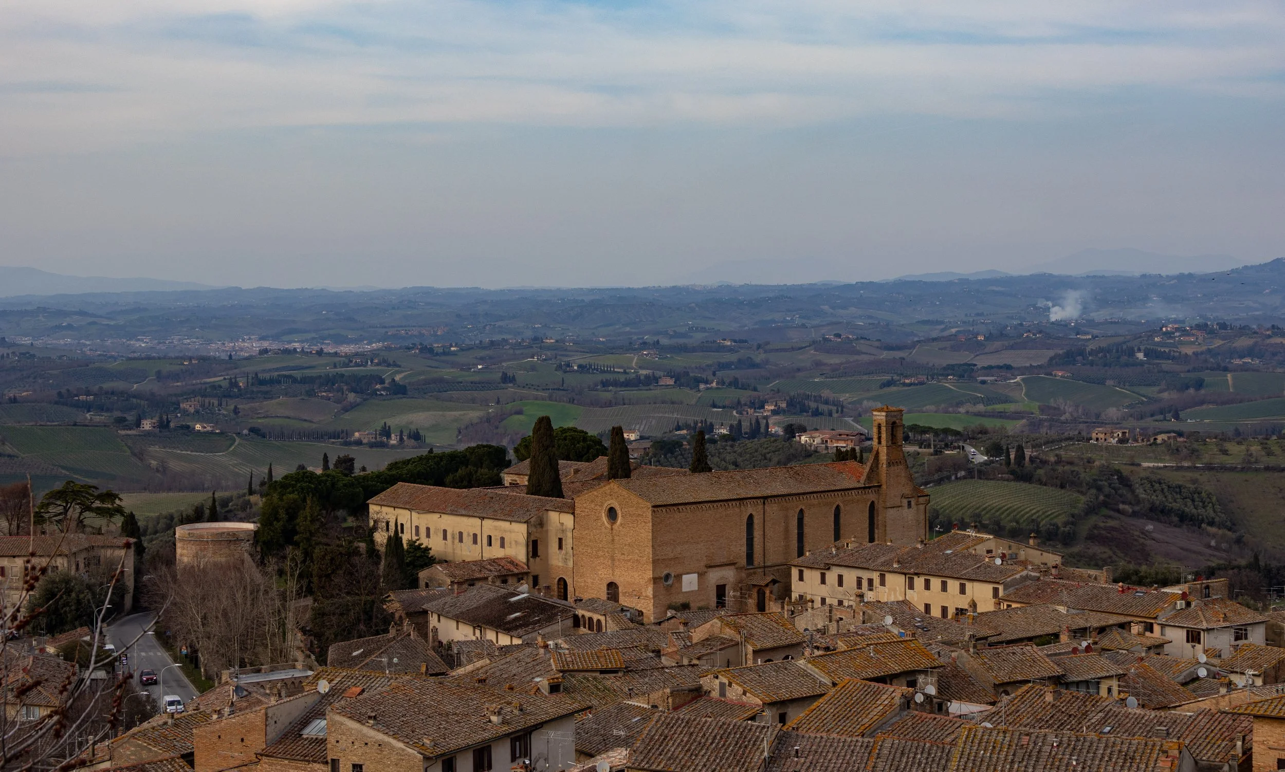 San Gimignano, Italy | A panoramic view over the medieval rooftops of San Gimignano, where centuries-old architecture meets the rolling hills of the Tuscan countryside. 