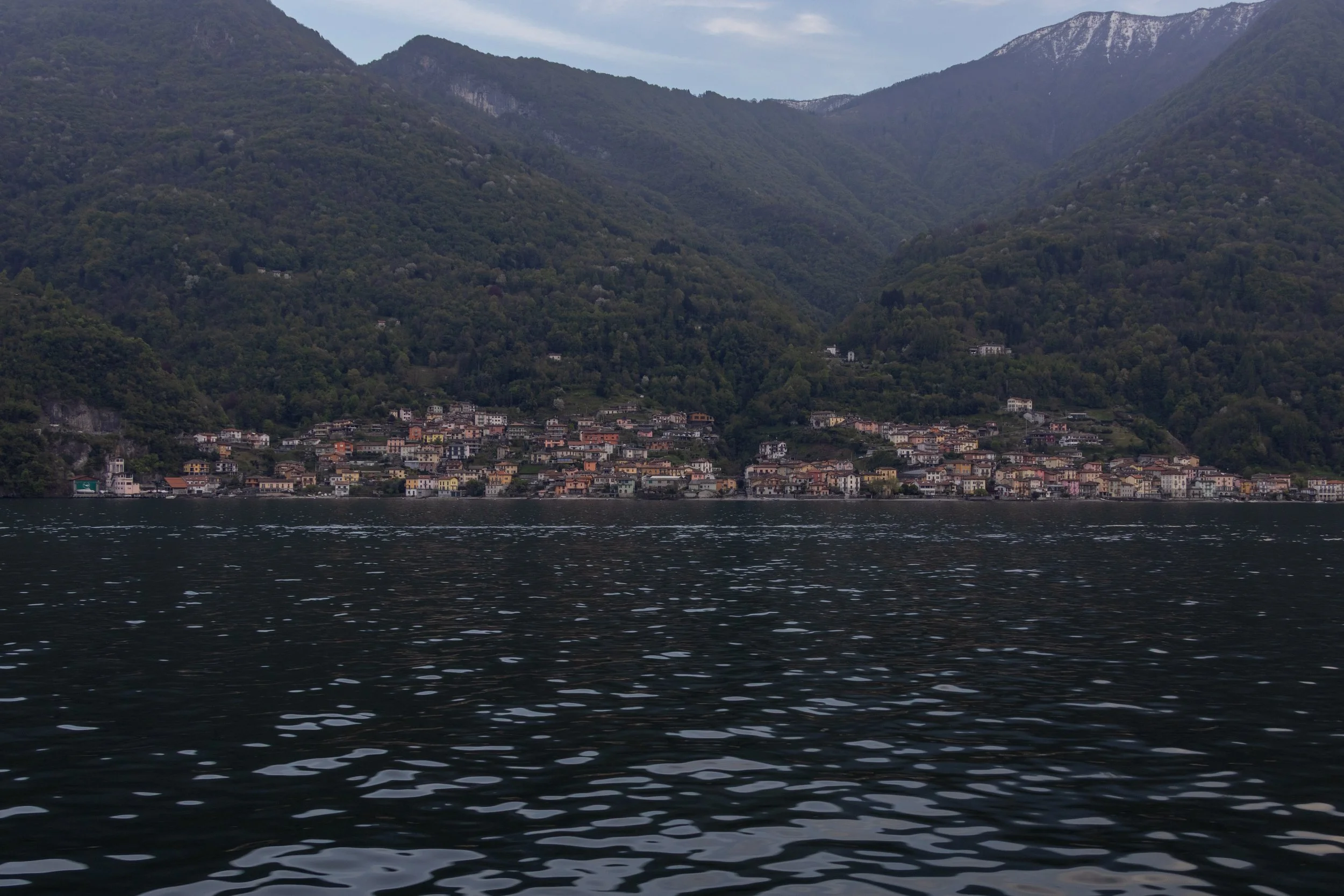 Lake Como, Italy | A colorful lakeside village sits beneath the forested mountains of Lake Como. 