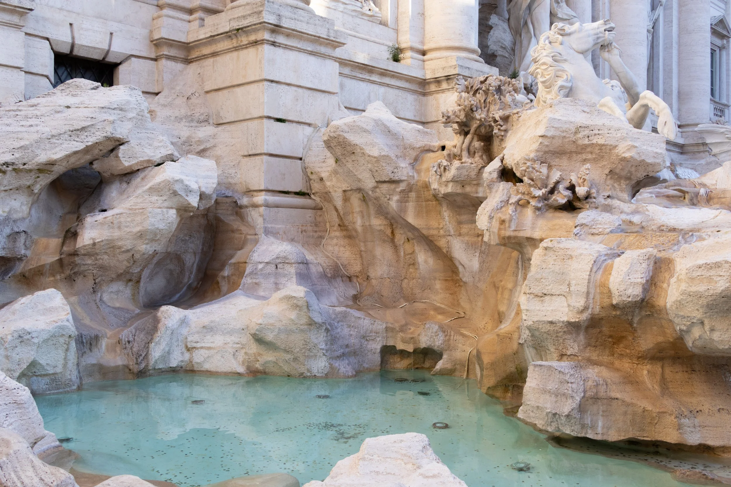 Rome, Italy | A closer view of the Trevi fountain's marble sculptures and turquoise waters.