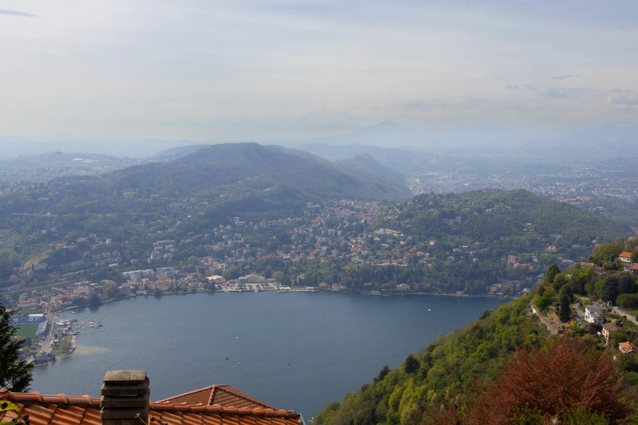 Lake Como, Italy | A panoramic view overlooking Lake Como, surrounded by layered hills and lakeside communities. 