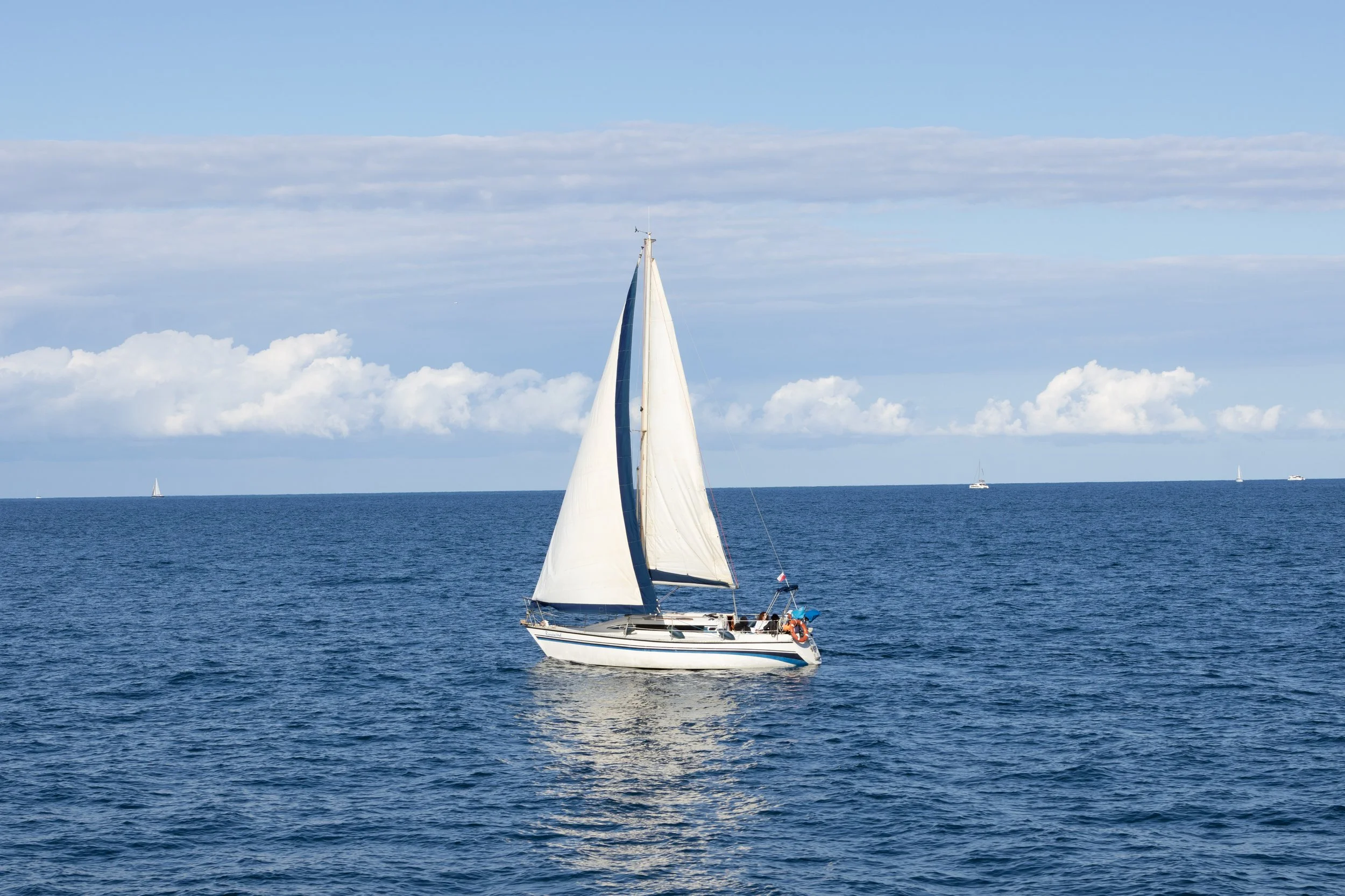 Barcelona, Spain | A sailboat glides across the Mediterranean Sea. 