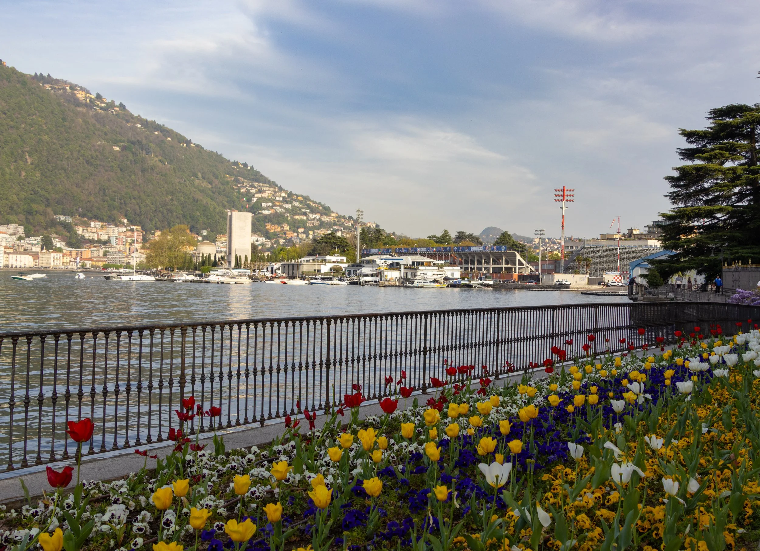 Lake Como, Italy | Colorful spring flowers line the waterfront, overlooking the calm waters of Lake Como.