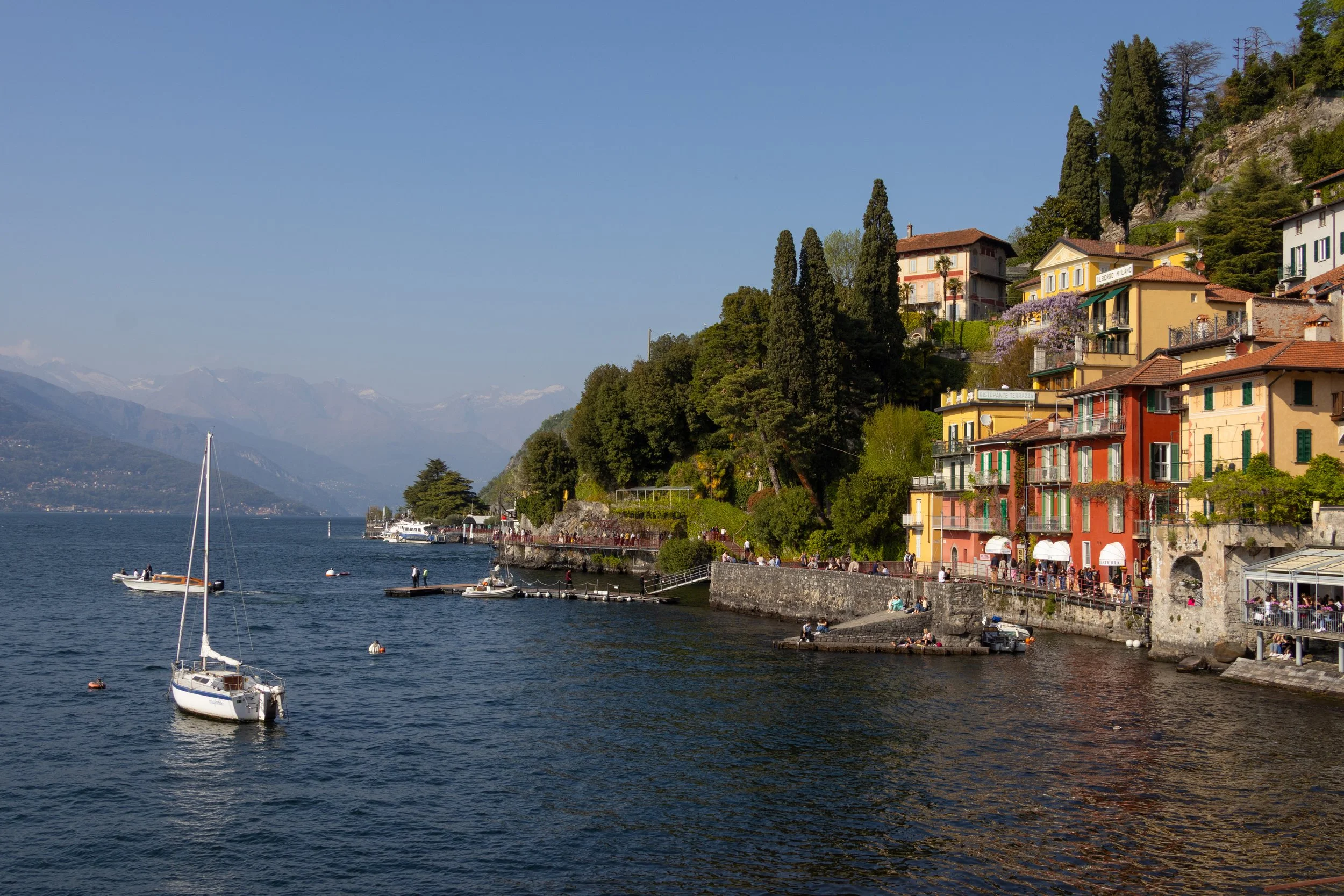 Varenna, Italy | A sailboat rests on the waters of Lake Como beside the colorful waterfront of Varenna. 