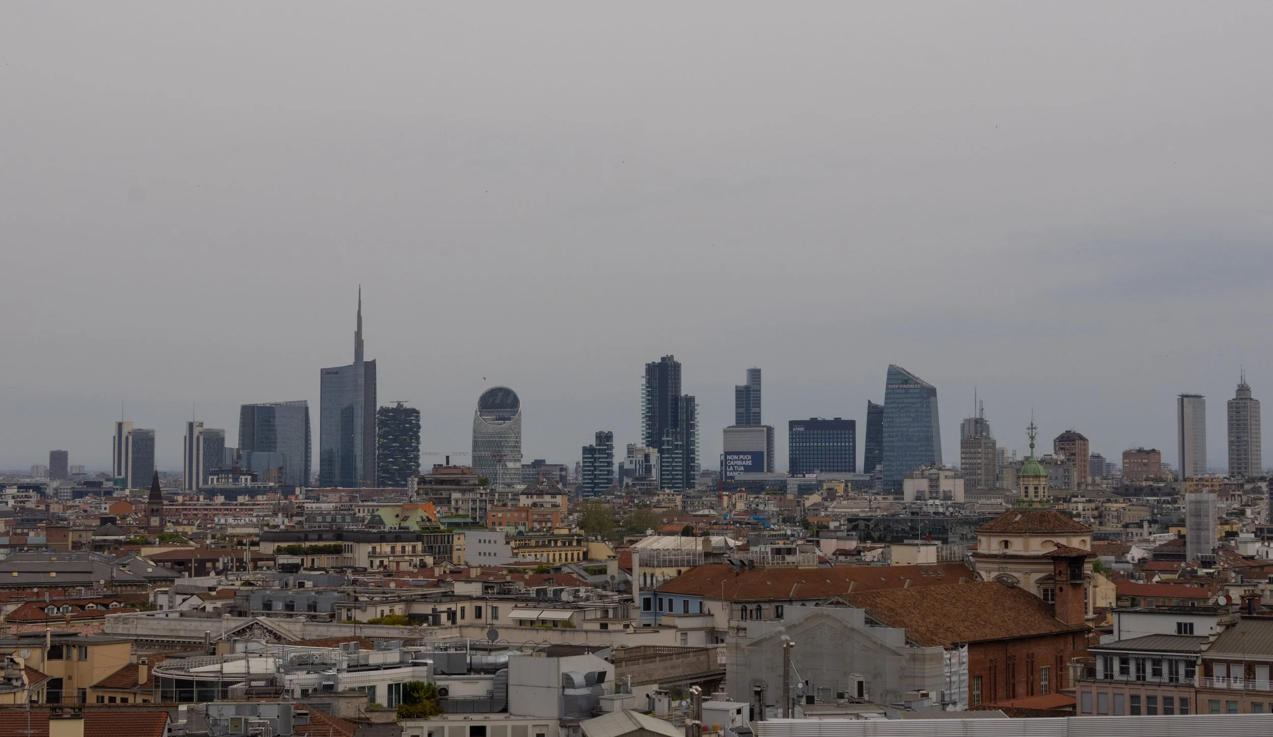 Milan, Italy | Milan's modern skyline rises beyond the city's historic rooftops, highlighting the contrast between old and new. 