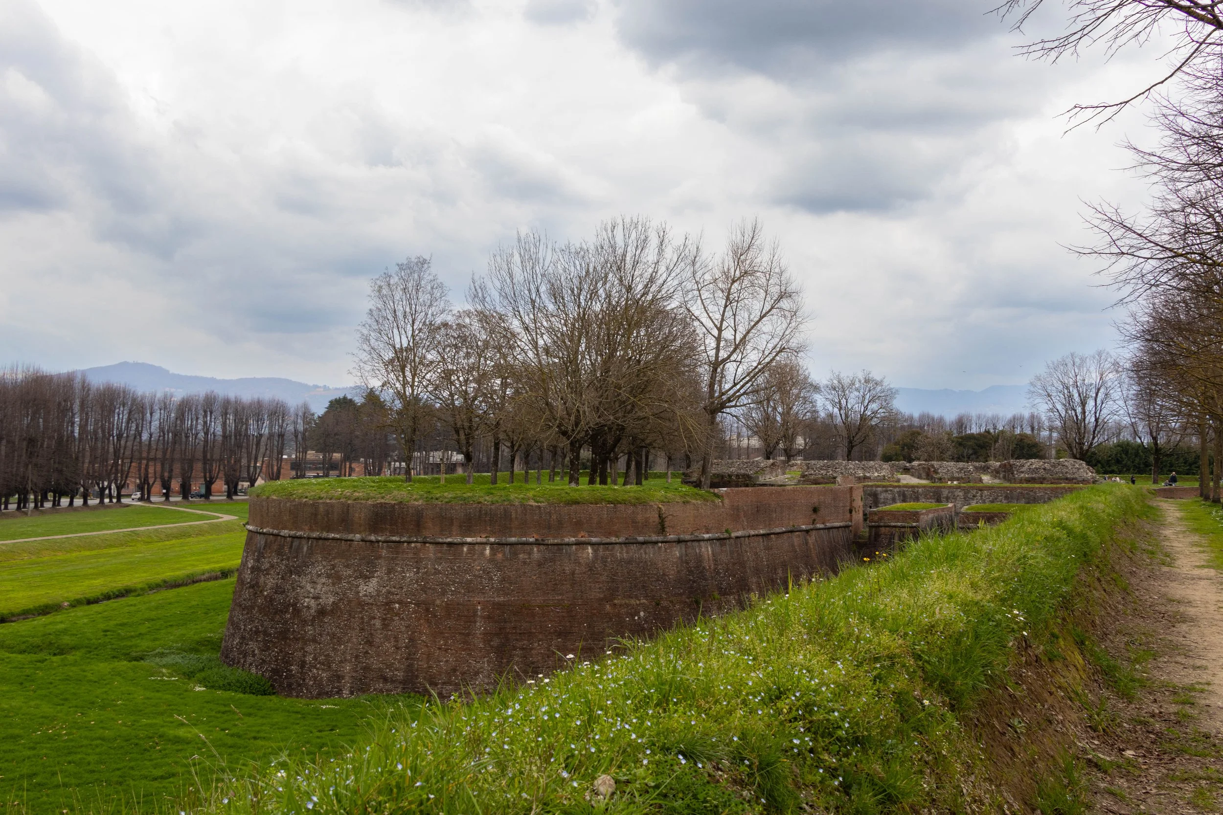 Lucca, Italy | Historic stone walls and quiet green paths surround the timeless city of Lucca, Italy. 