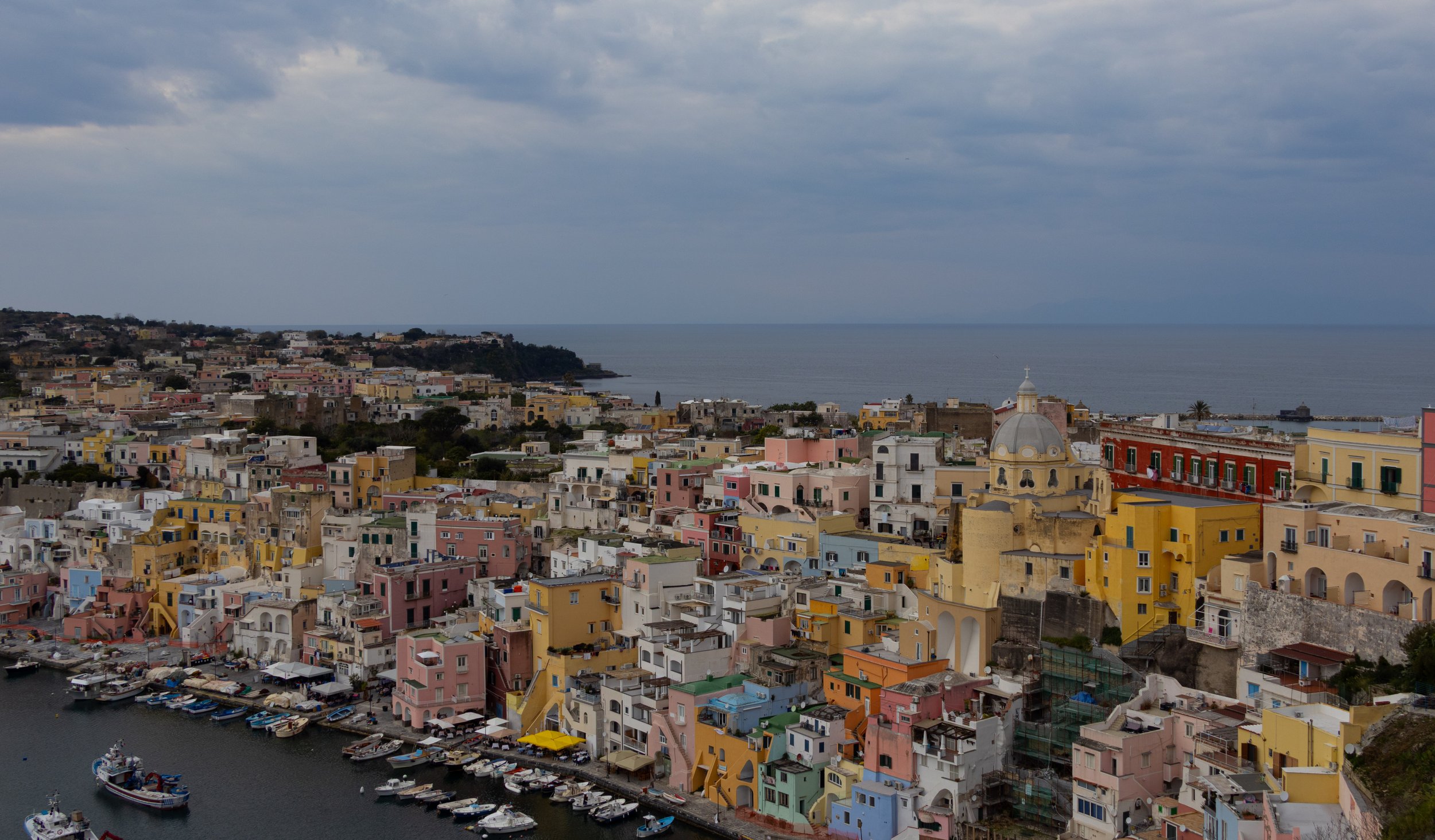 Procida, Italy | A panoramic view overlooks the colorful waterfront and harbor of procida. 